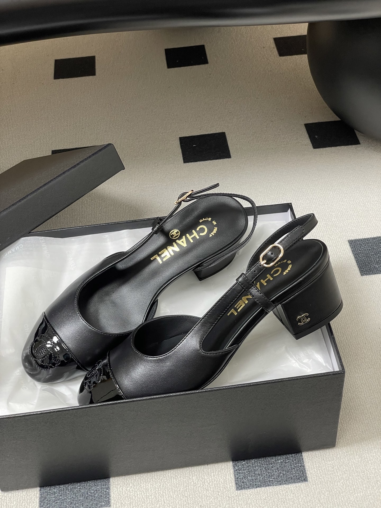 Pair of black Chanel slingback pumps with patent leather cap toe and gold CC logo on the block heel. - Hình 4