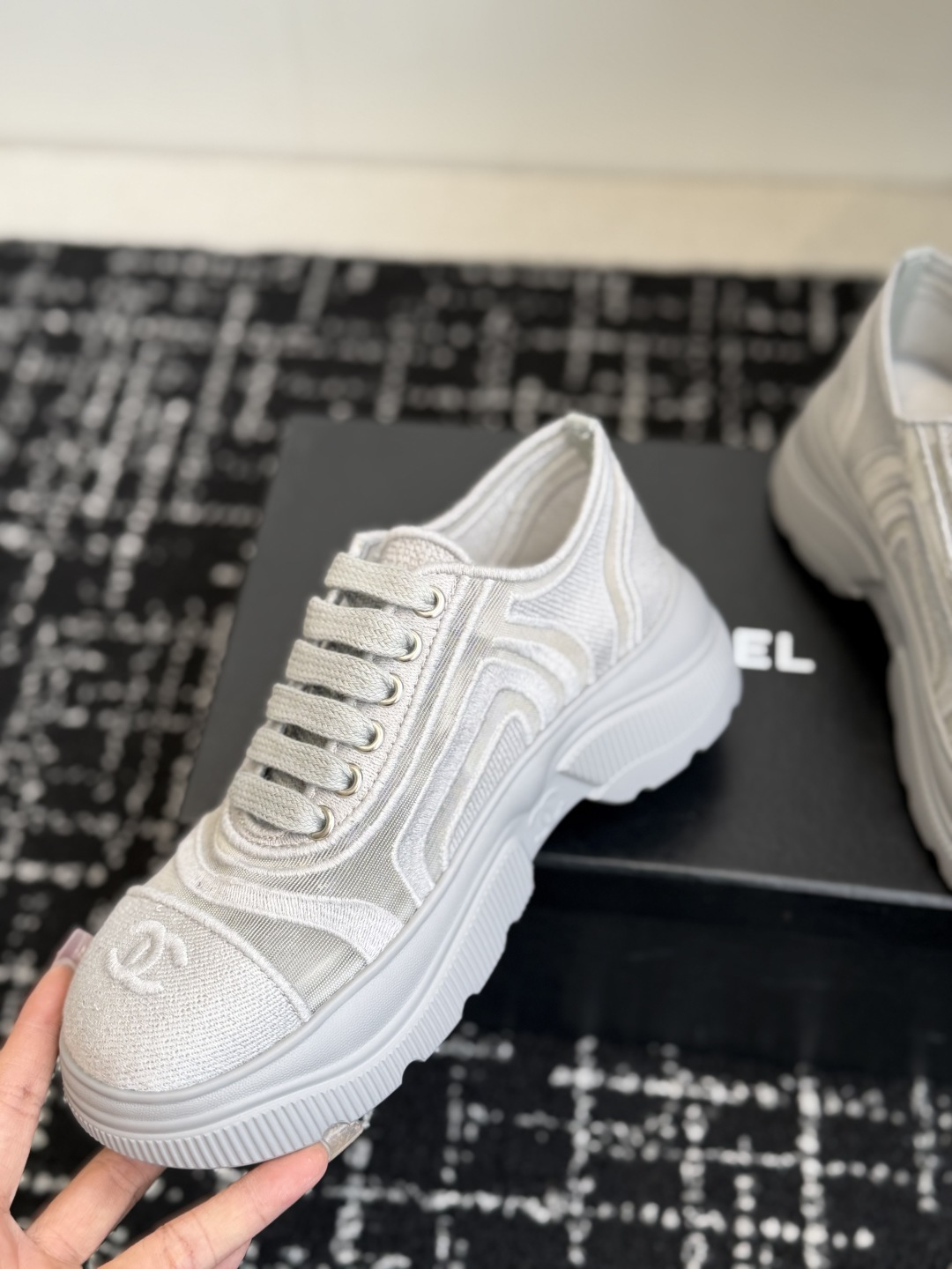 A pair of Chanel white mesh and fabric platform sneakers with the CC logo on the toe cap, displayed on a black box. - Hình 6