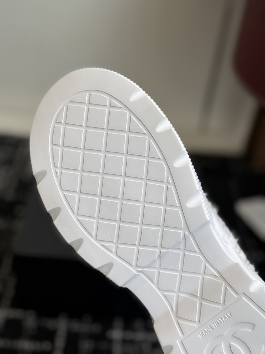 A pair of luxury white tweed sneakers with black rhinestone cap toes and chunky white soles, presented on a black designer shoe box. - Hình 9