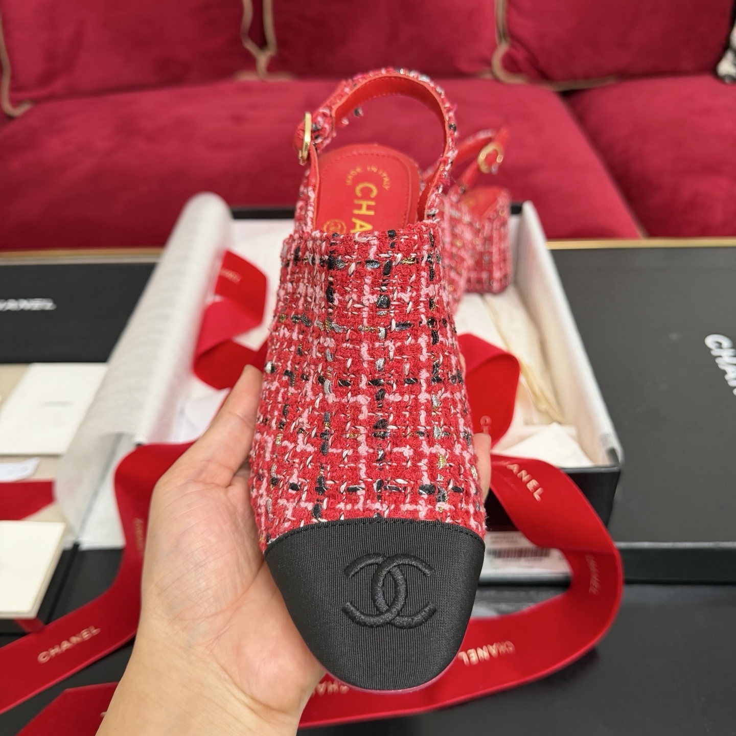 Luxury Chanel slingback pumps in red and pink tweed with black fabric toe caps and interlocking CC logo on a black designer box. - Hình 3