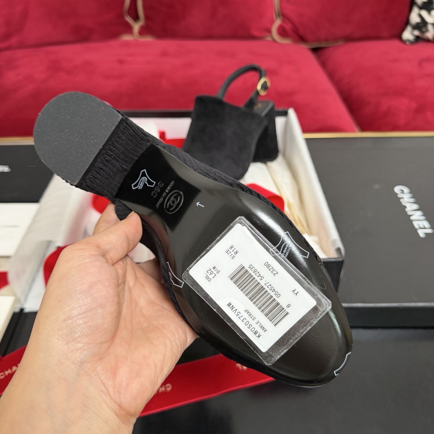 A pair of black Chanel ribbed fabric slingback pumps with a CC logo on the cap toe, displayed in their original box with a red ribbon. - Hình 9