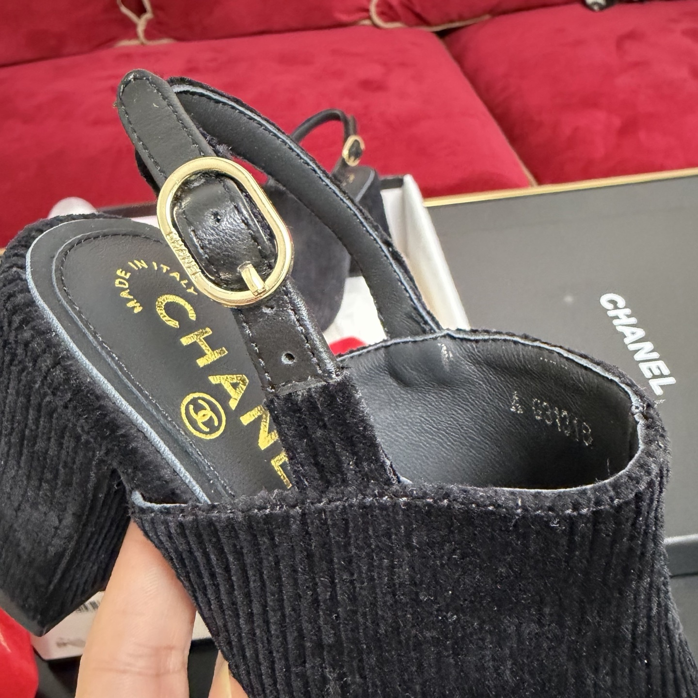 A pair of black Chanel ribbed fabric slingback pumps with a CC logo on the cap toe, displayed in their original box with a red ribbon. - Hình 7