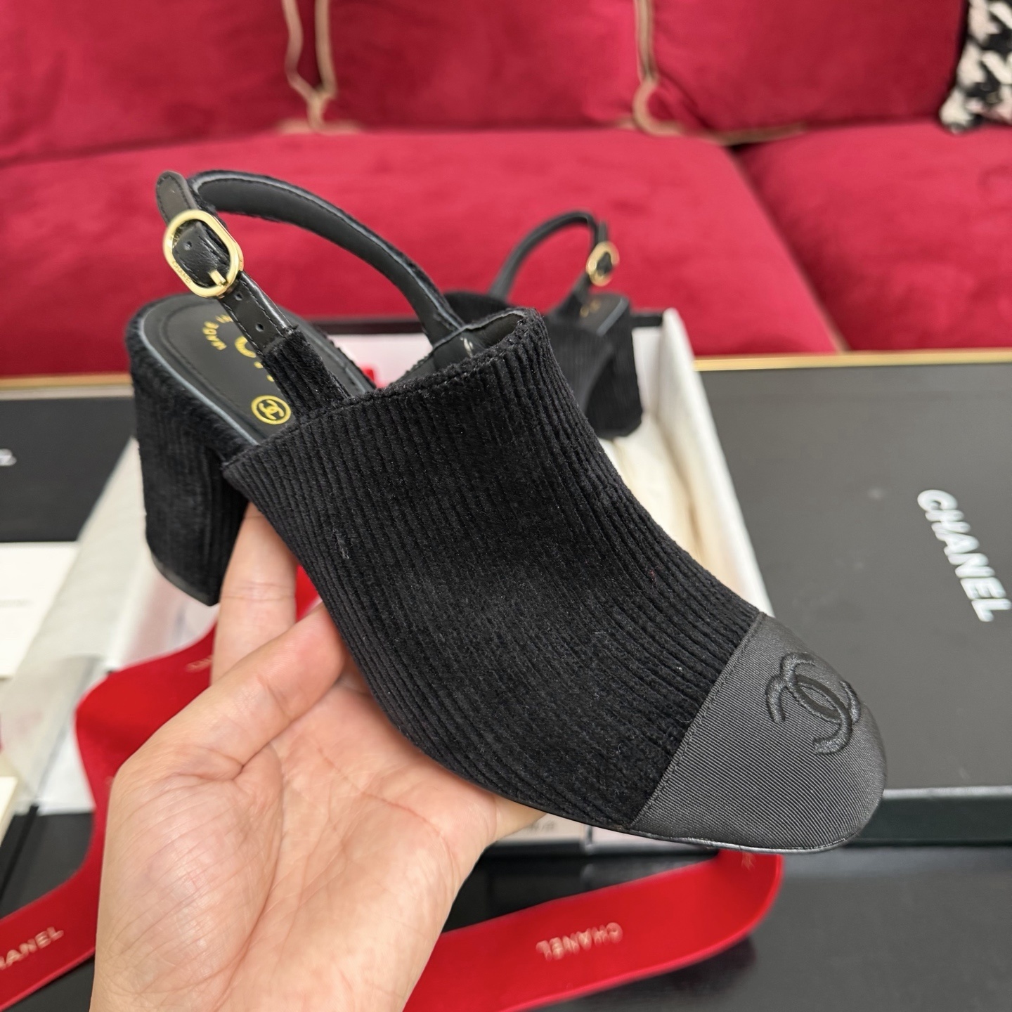 A pair of black Chanel ribbed fabric slingback pumps with a CC logo on the cap toe, displayed in their original box with a red ribbon. - Hình 4