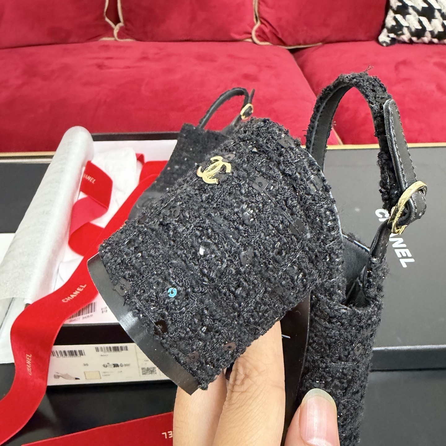 Pair of Chanel black tweed slingback pumps with sequins and CC logo on toe cap, displayed in original packaging with red ribbon. - Hình 8