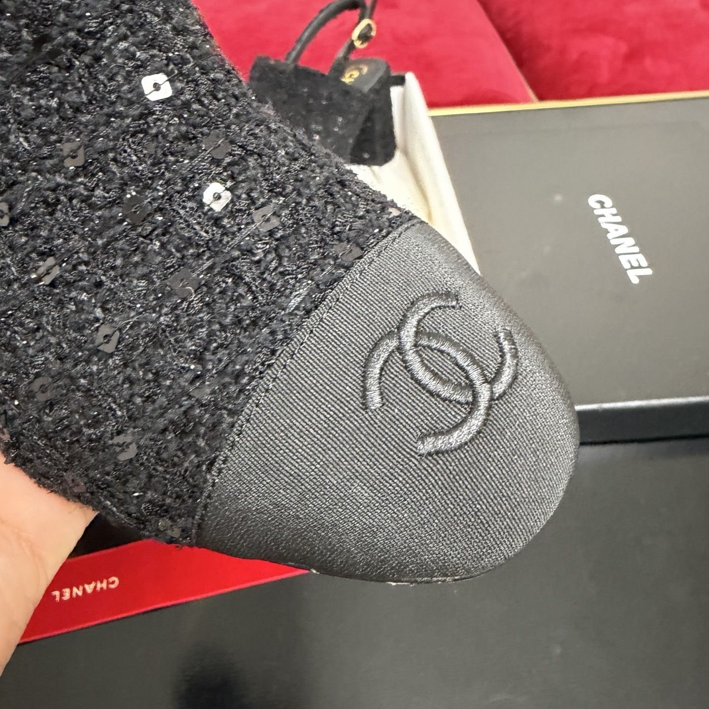 Pair of Chanel black tweed slingback pumps with sequins and CC logo on toe cap, displayed in original packaging with red ribbon. - Hình 6