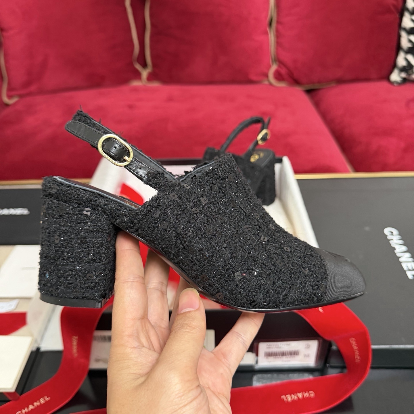Pair of Chanel black tweed slingback pumps with sequins and CC logo on toe cap, displayed in original packaging with red ribbon. - Hình 5