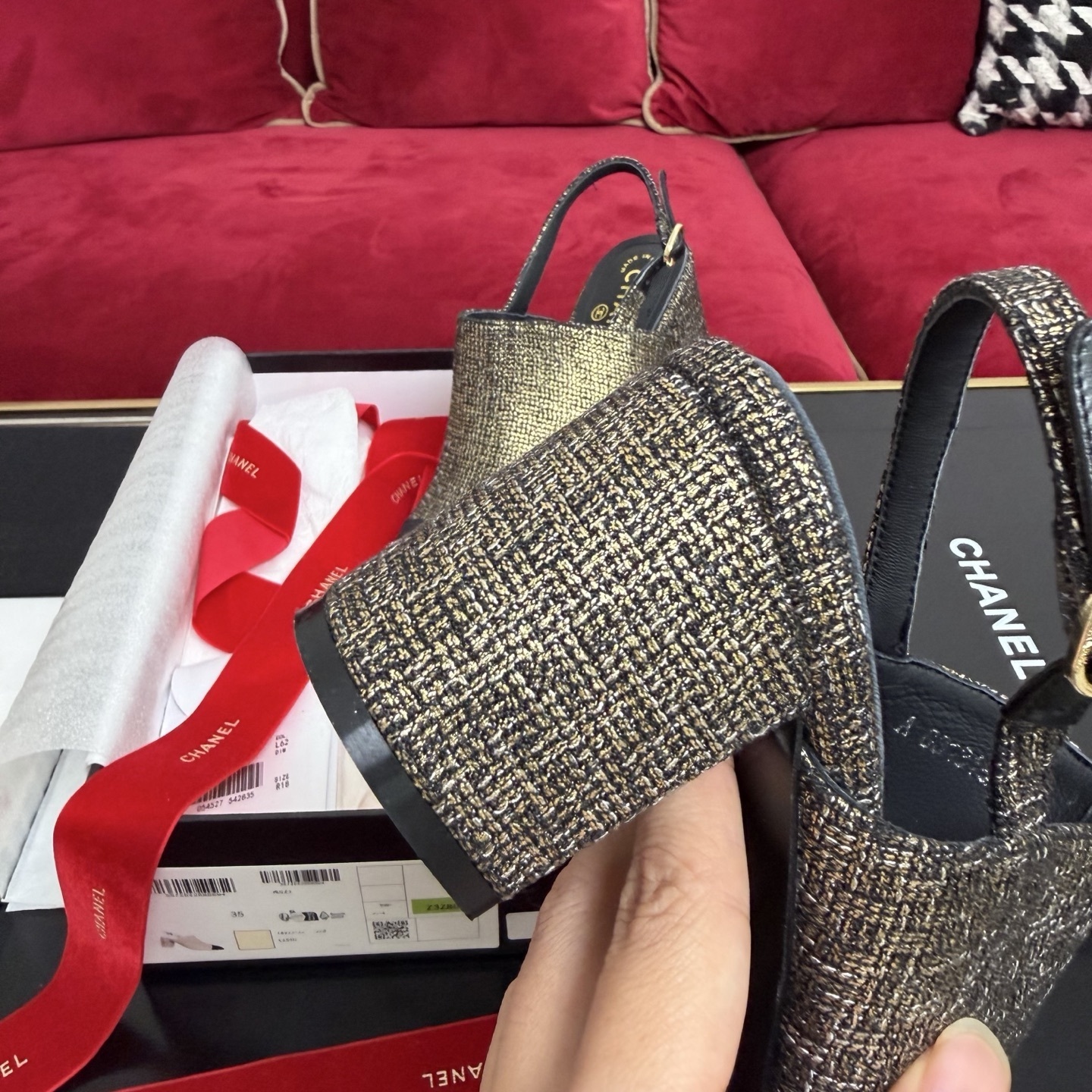 Pair of Chanel gold metallic tweed slingback pumps with black CC logo cap toe and block heel sitting in a gift box with red ribbon. - Hình 8