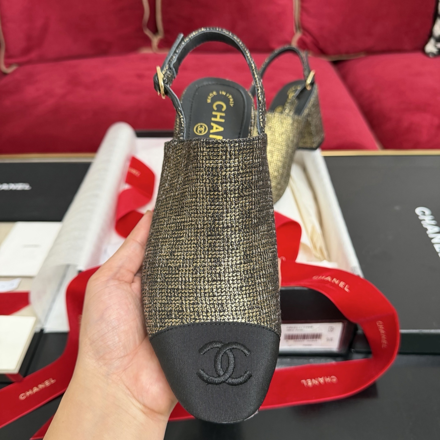 Pair of Chanel gold metallic tweed slingback pumps with black CC logo cap toe and block heel sitting in a gift box with red ribbon. - Hình 3