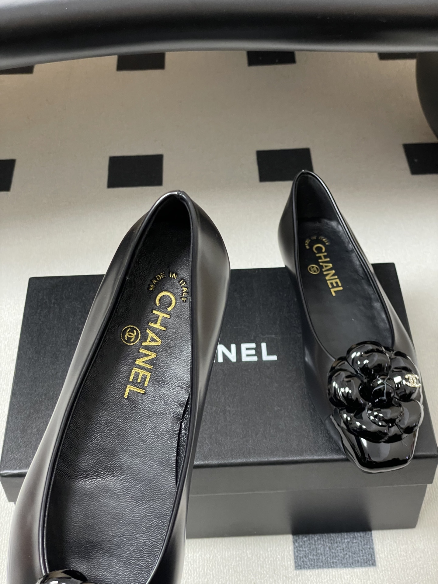 A pair of black Chanel ballet flats featuring a patent leather camellia flower with a small CC logo on the toe cap. - Hình 7