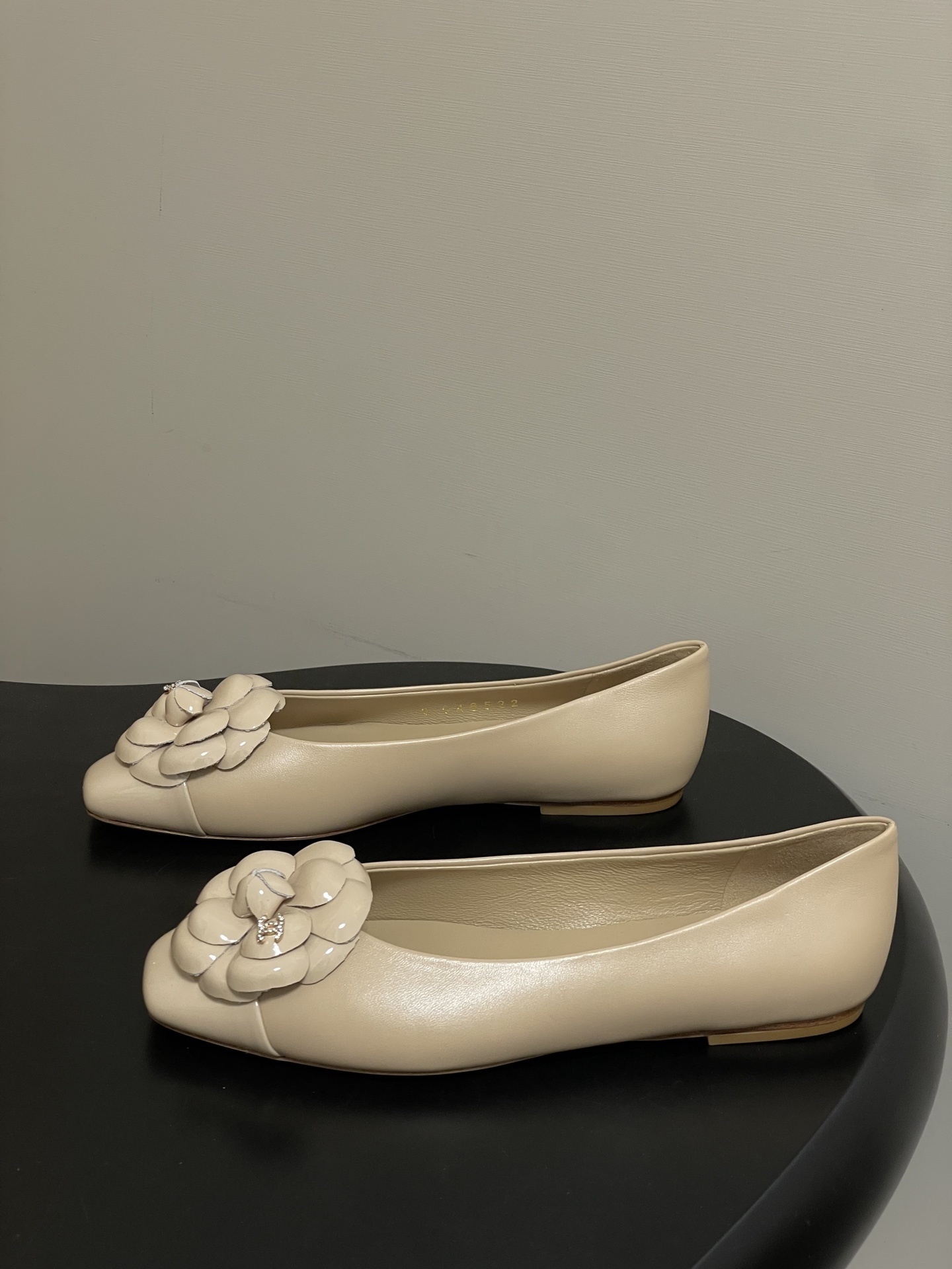 Pair of Chanel beige leather ballet flats featuring iconic camellia flower and crystal CC logo on the toe. - Hình 3
