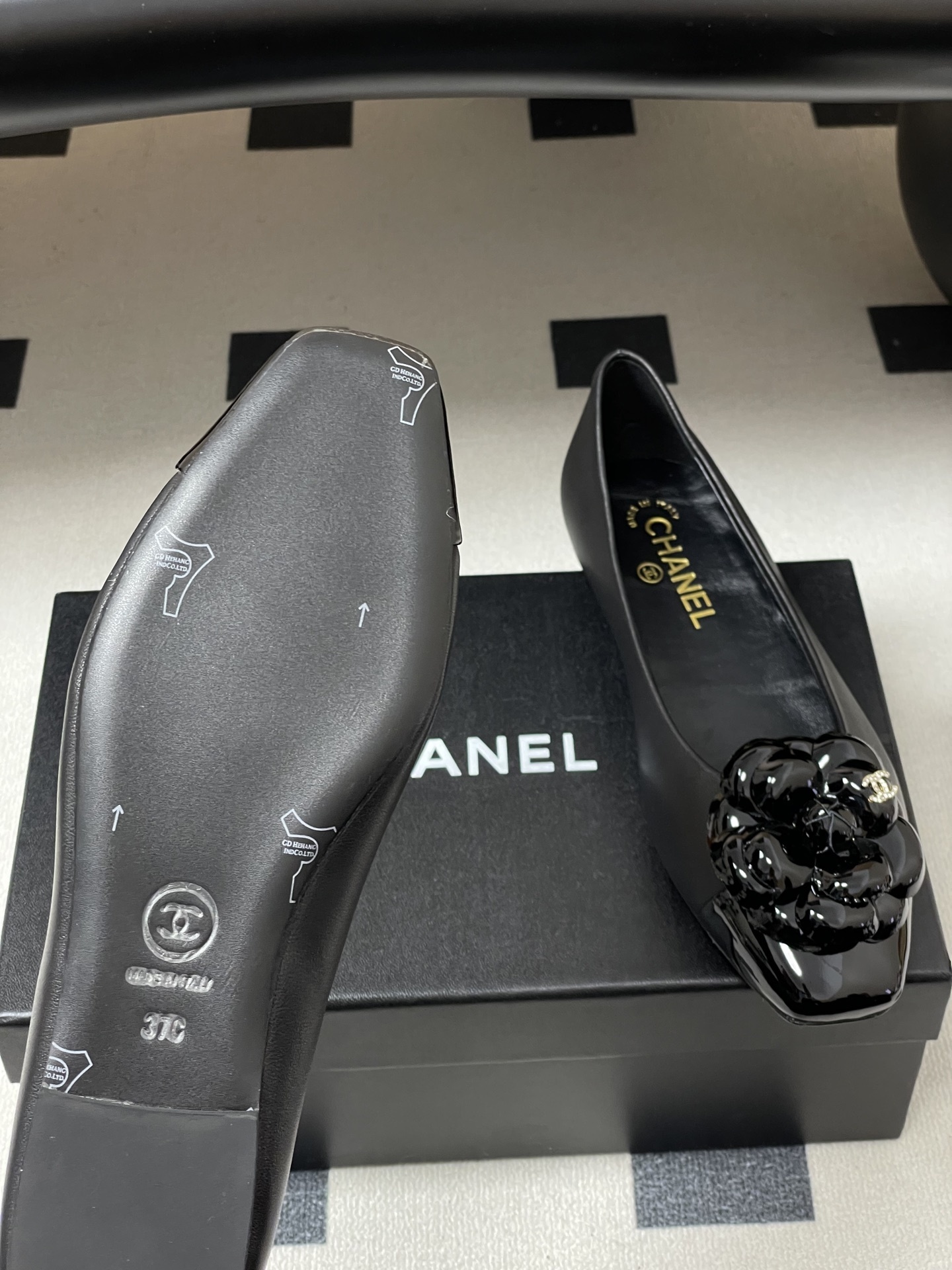 A pair of black Chanel ballet flats featuring a 3D camellia flower and patent leather square toe. - Hình 8