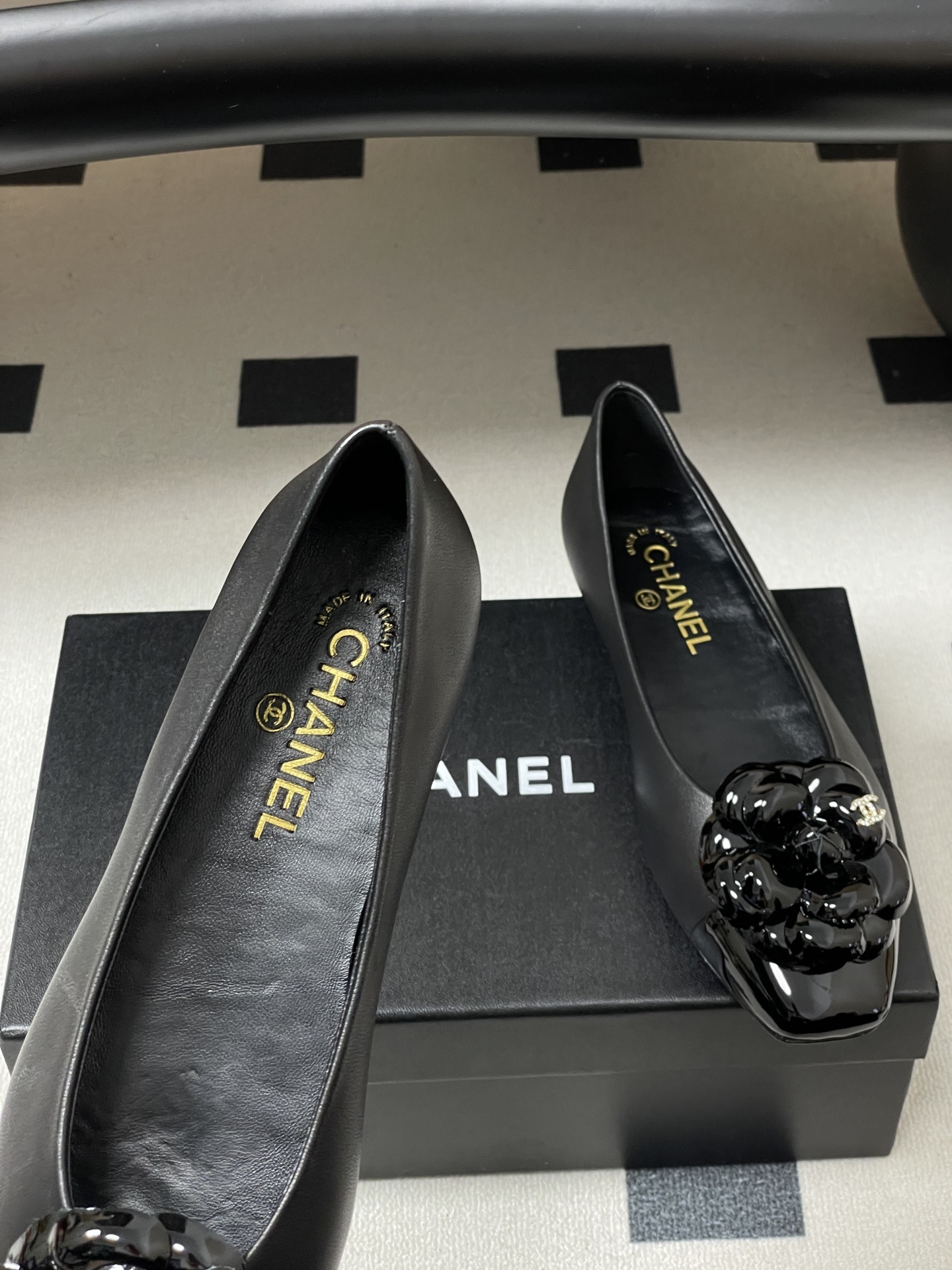 A pair of black Chanel ballet flats featuring a 3D camellia flower and patent leather square toe. - Hình 7