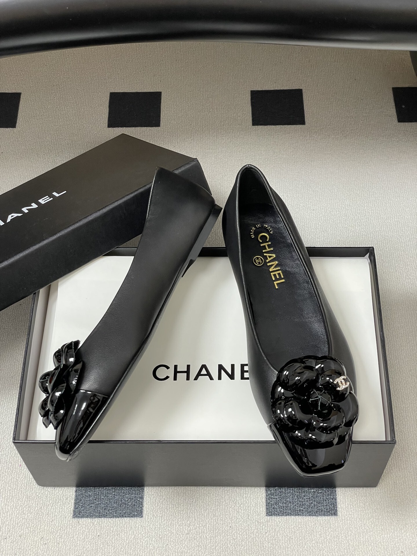 A pair of black Chanel ballet flats featuring a 3D camellia flower and patent leather square toe. - Hình 6