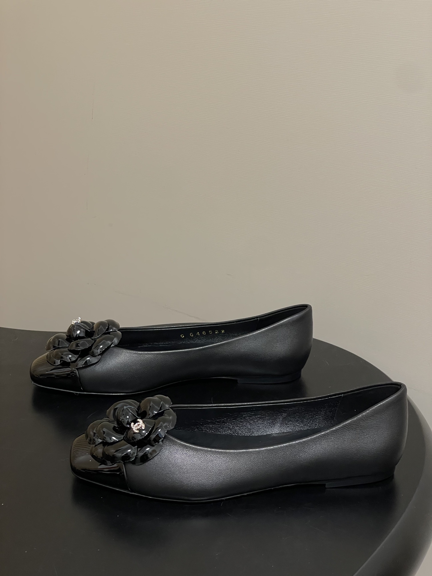 A pair of black Chanel ballet flats featuring a 3D camellia flower and patent leather square toe. - Hình 3