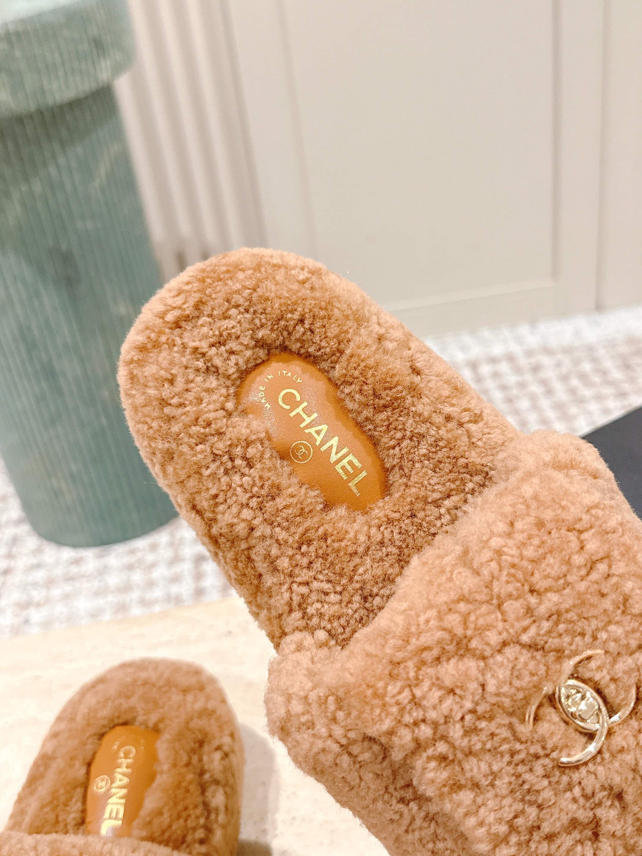 A pair of luxury Chanel shearling fluffy slide sandals in camel brown featuring gold CC logos on the straps. - Hình 7