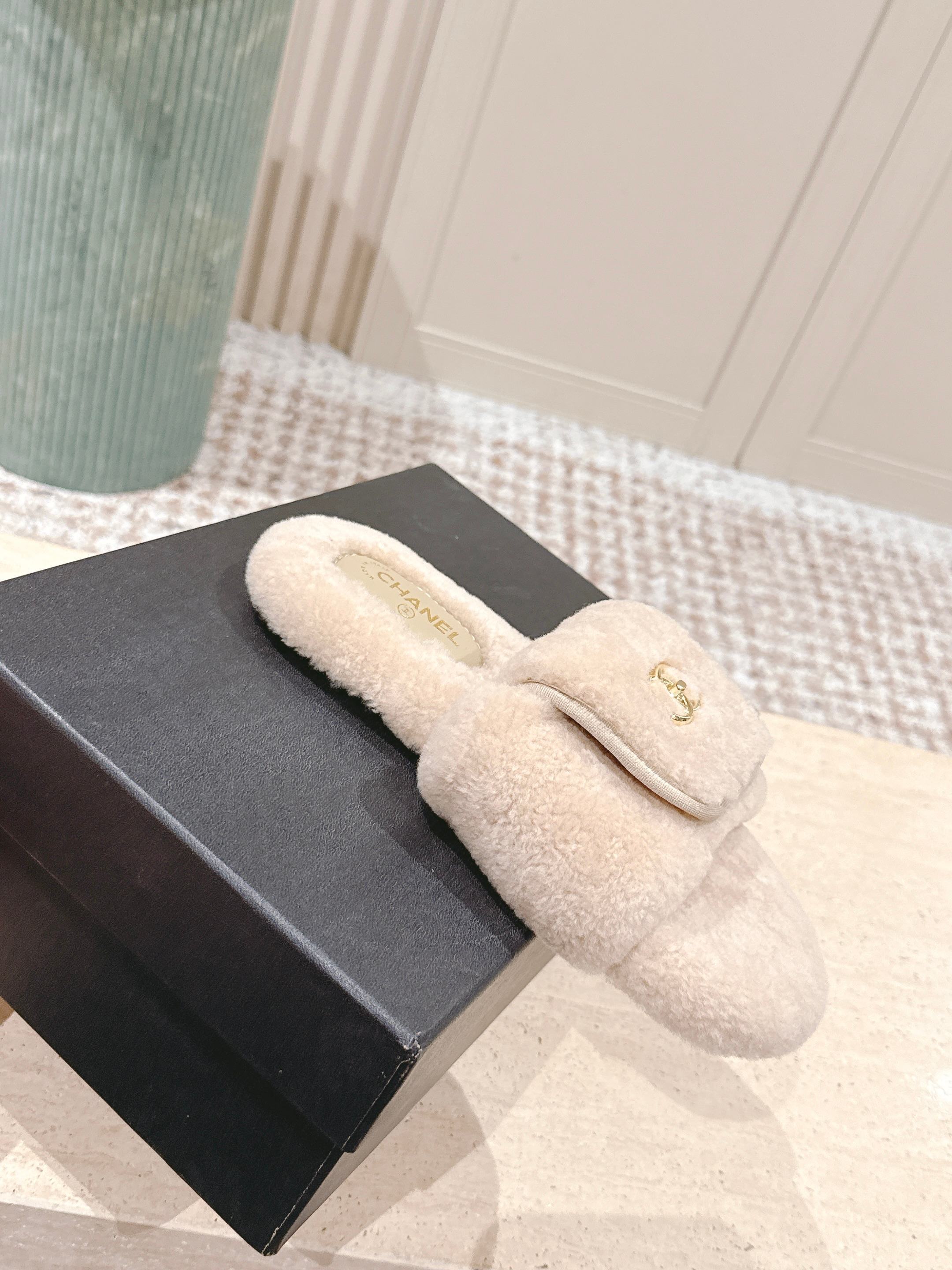 Luxury beige Chanel shearling slides with gold CC logo hardware on a display stand - Hình 4