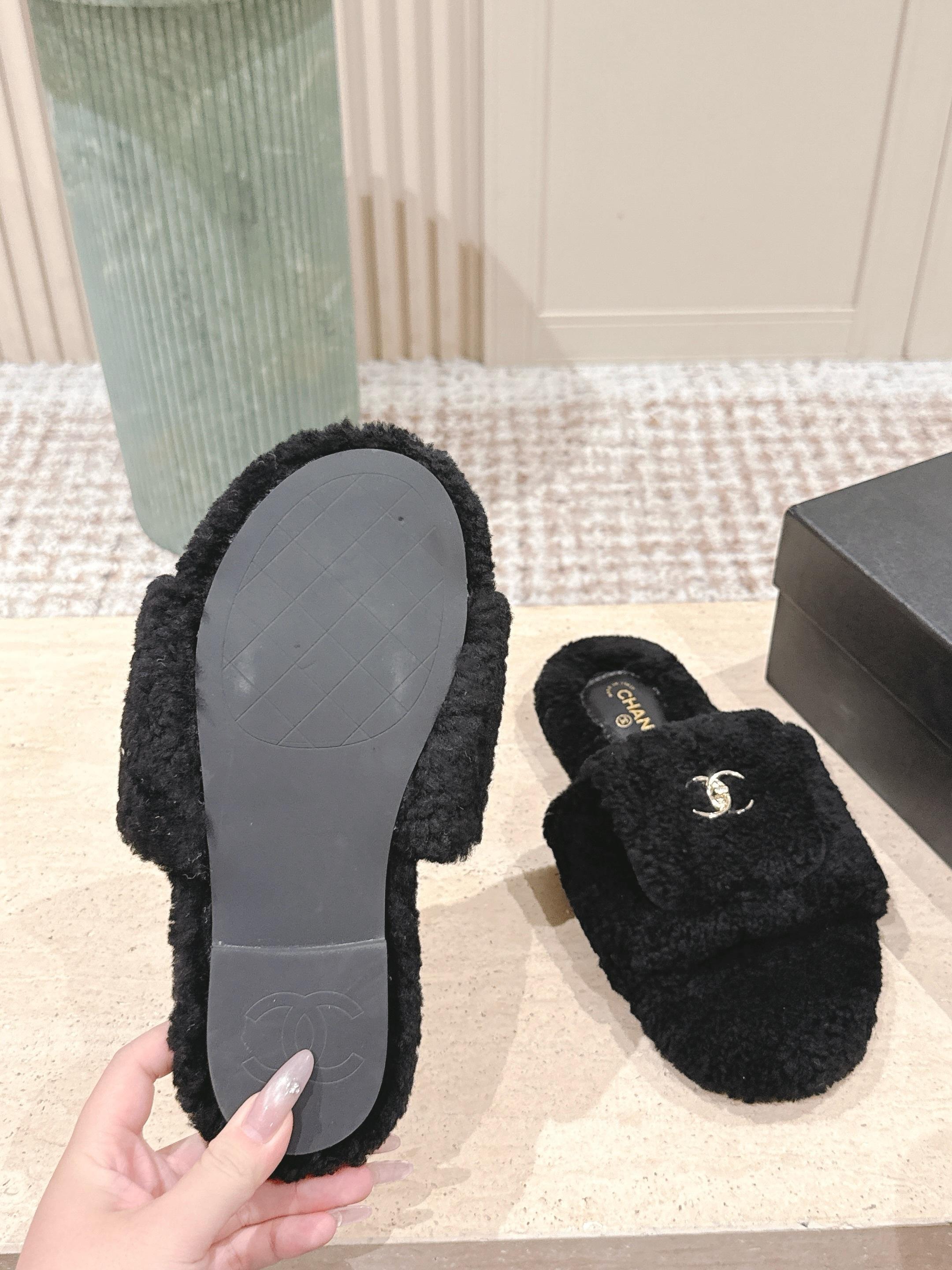A pair of luxury black fuzzy Chanel shearling slides featuring silver interlocking CC logos on the wide straps. - Hình 9