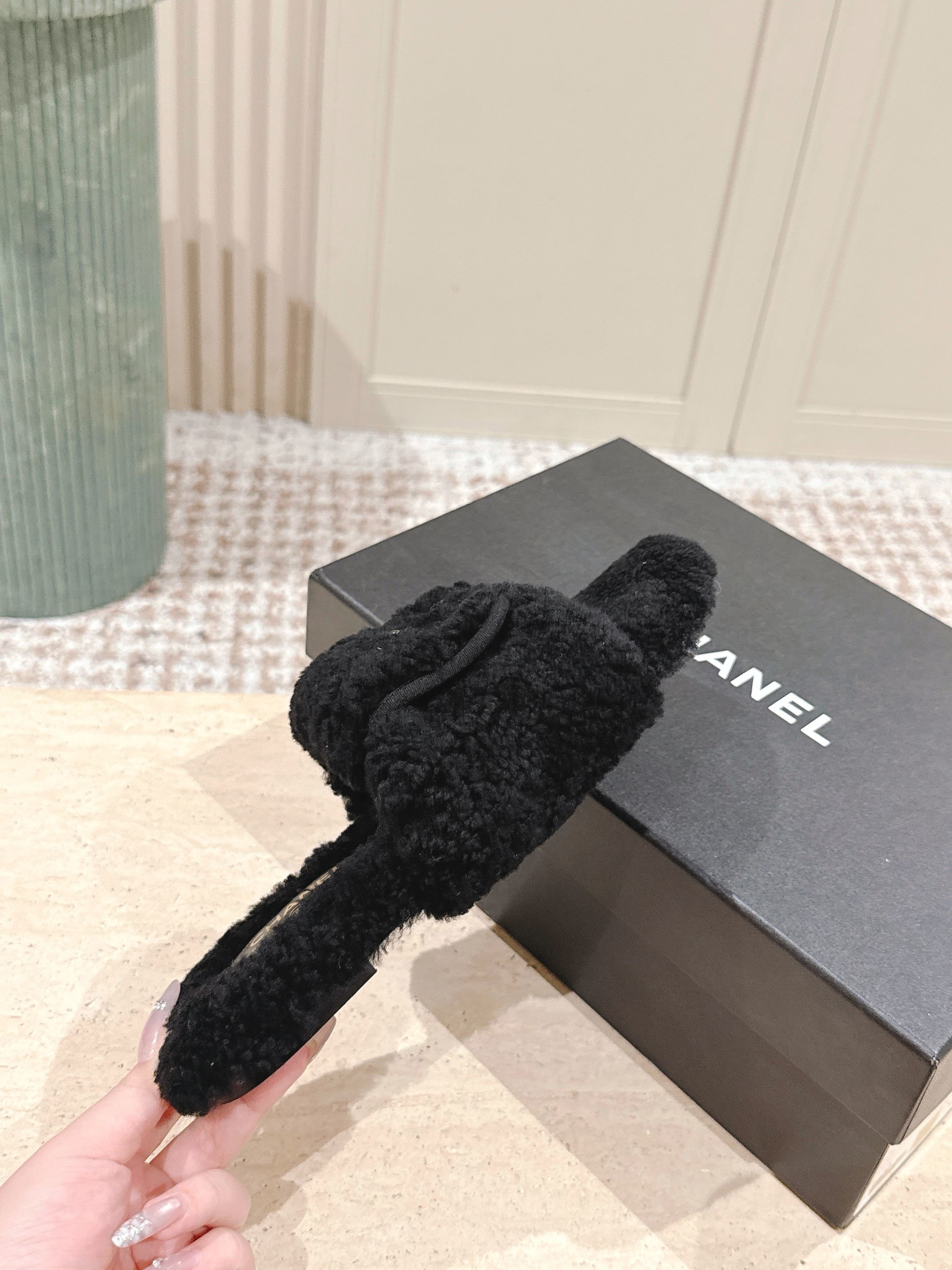 A pair of luxury black fuzzy Chanel shearling slides featuring silver interlocking CC logos on the wide straps. - Hình 7