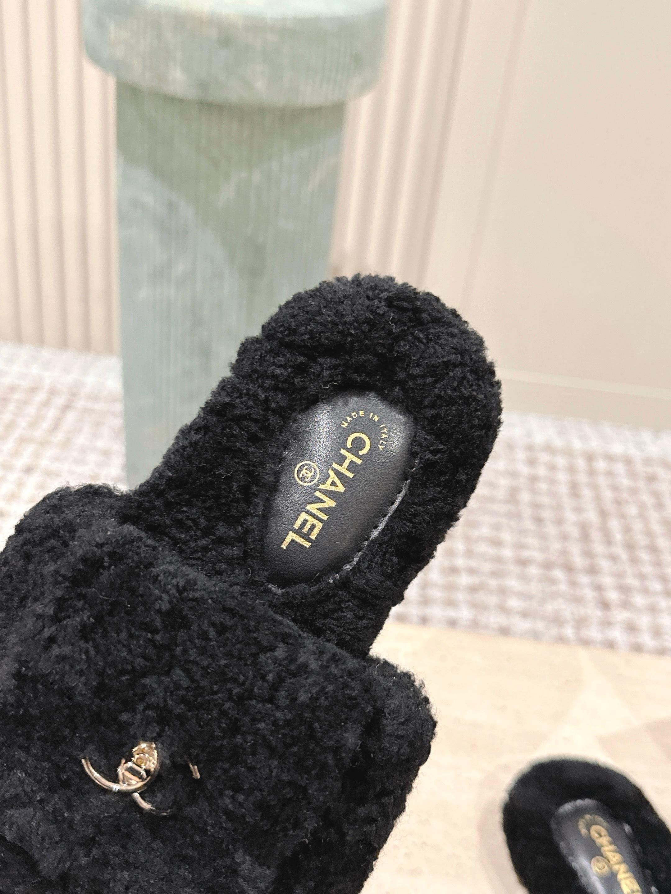 A pair of luxury black fuzzy Chanel shearling slides featuring silver interlocking CC logos on the wide straps. - Hình 6