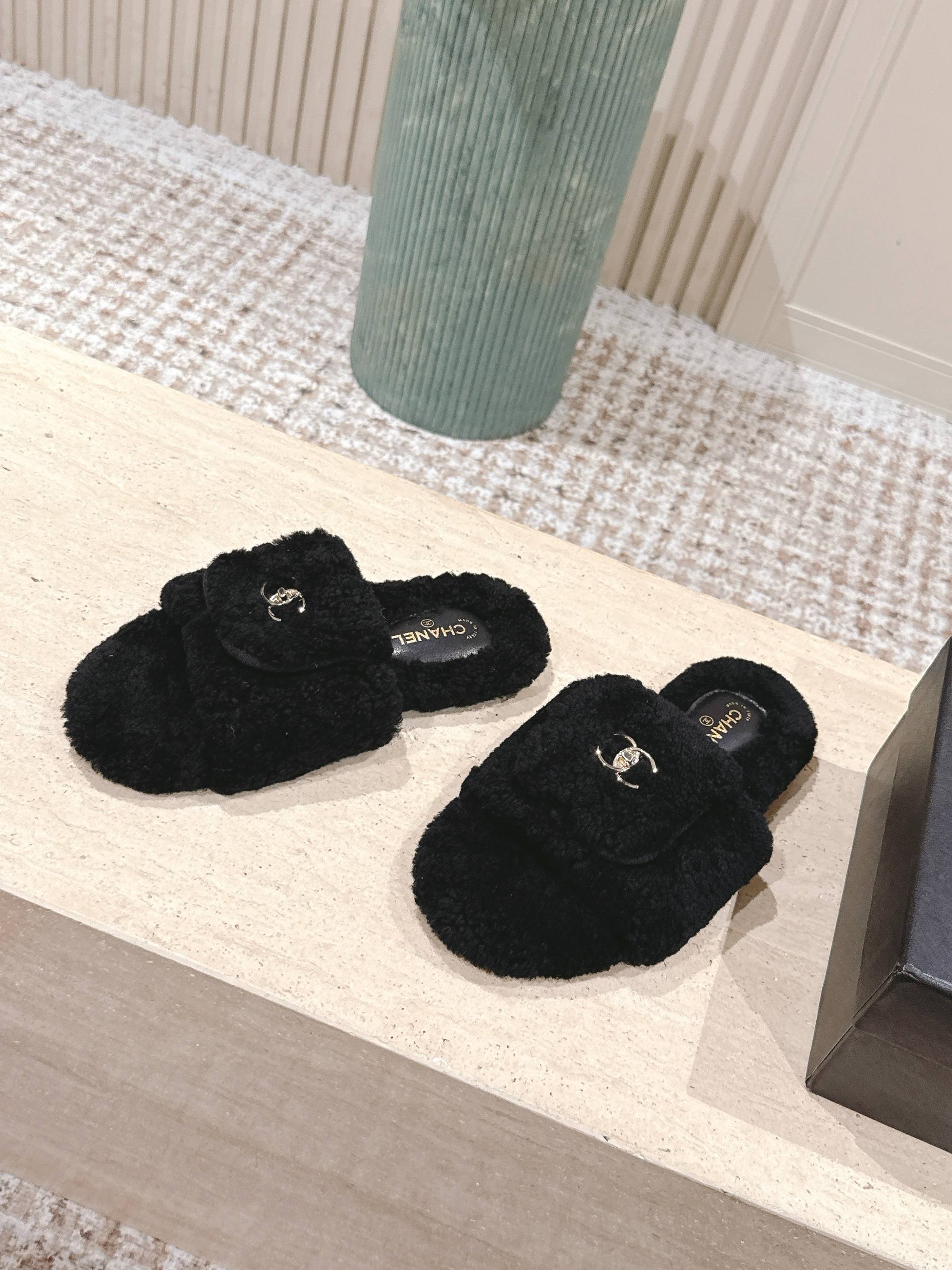 A pair of luxury black fuzzy Chanel shearling slides featuring silver interlocking CC logos on the wide straps. - Hình 3