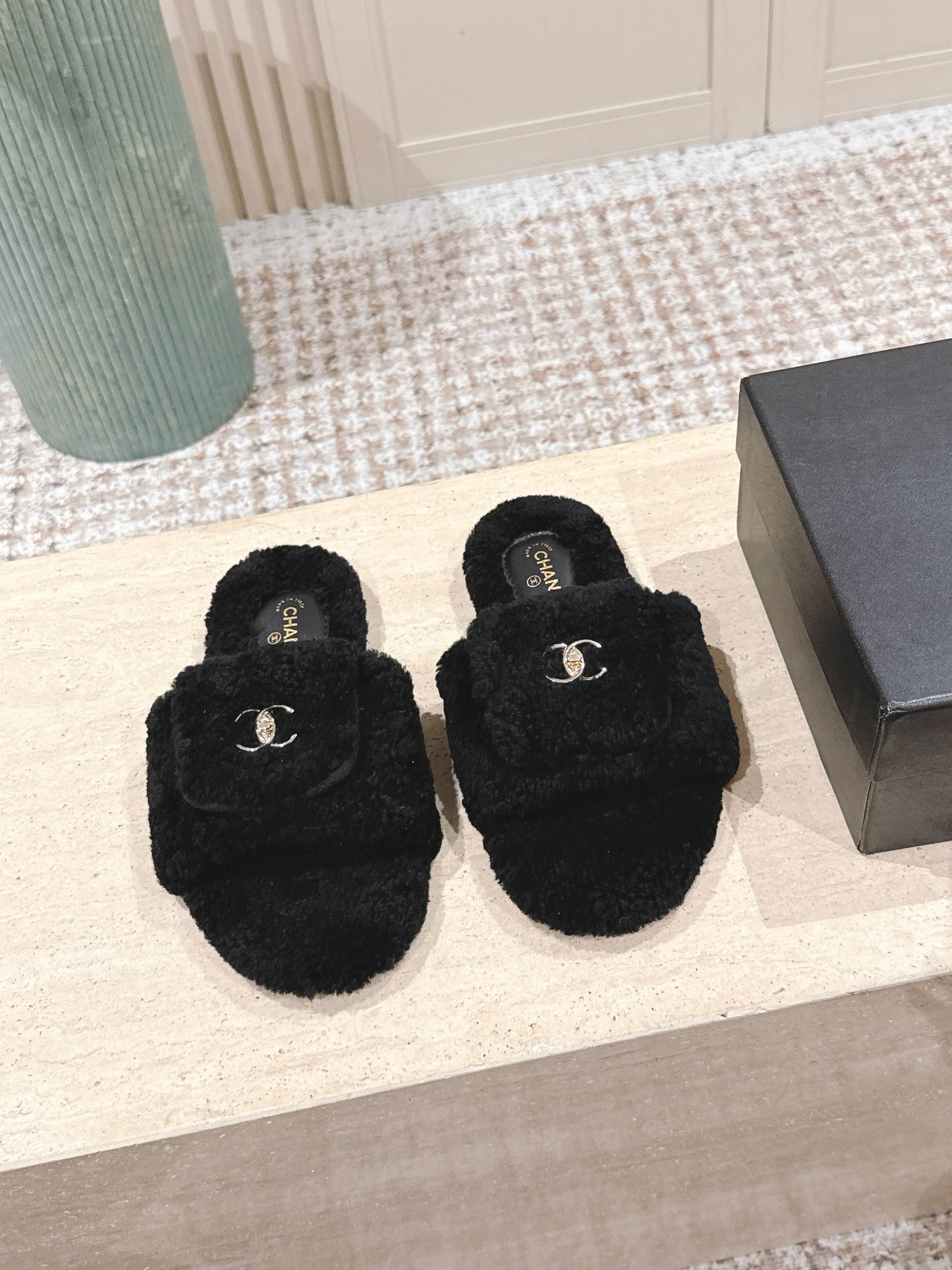 A pair of luxury black fuzzy Chanel shearling slides featuring silver interlocking CC logos on the wide straps. - Hình 2