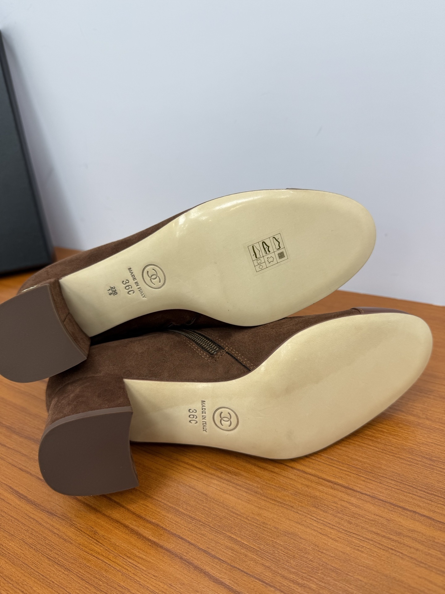 A pair of stylish brown suede ankle boots with a smooth leather cap-toe and block heels displayed on a wooden surface. - Hình 9