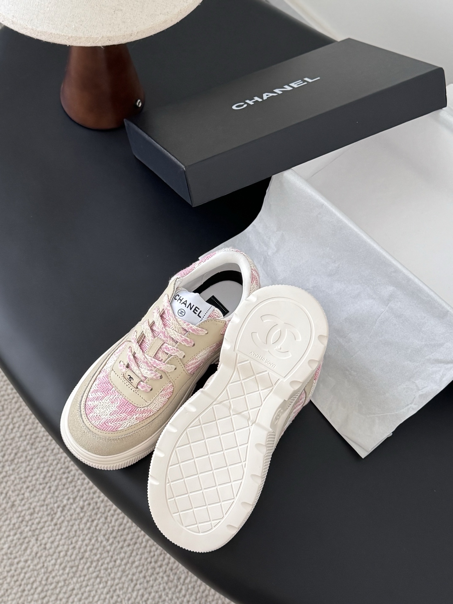 A pair of Chanel pink and white tweed sneakers with beige suede accents and a chunky white sole next to a black Chanel box. - Hình 5