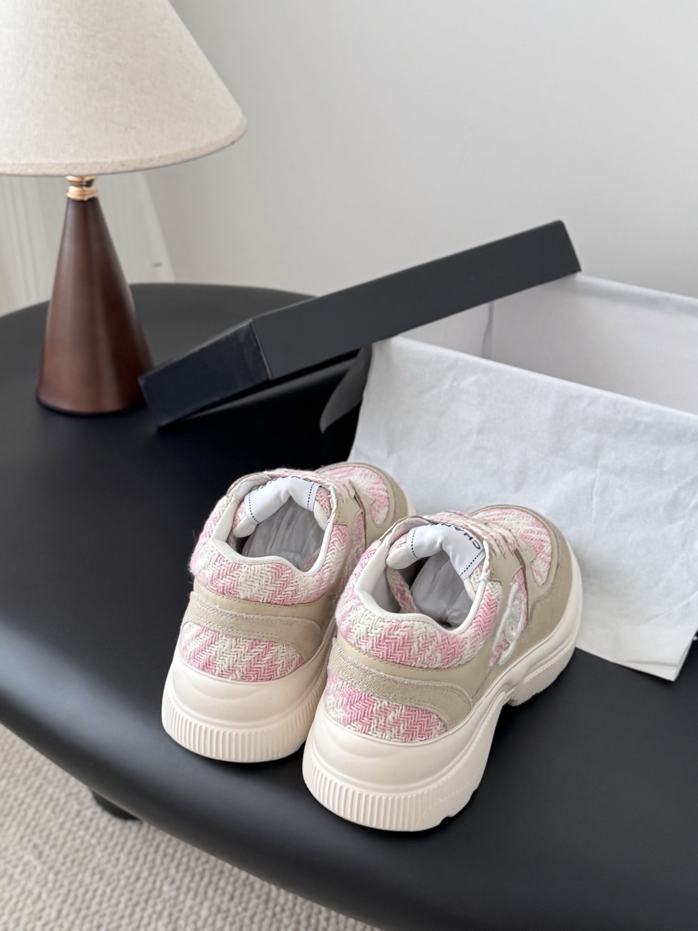 A pair of Chanel pink and white tweed sneakers with beige suede accents and a chunky white sole next to a black Chanel box. - Hình 3