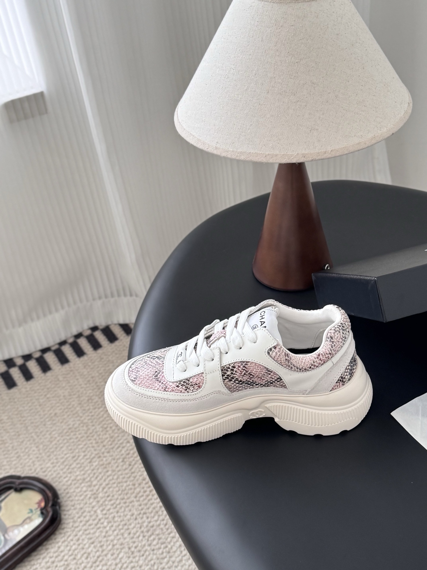 Chanel white leather sneakers with pink python print and chunky soles next to a black Chanel shoe box. - Hình 6