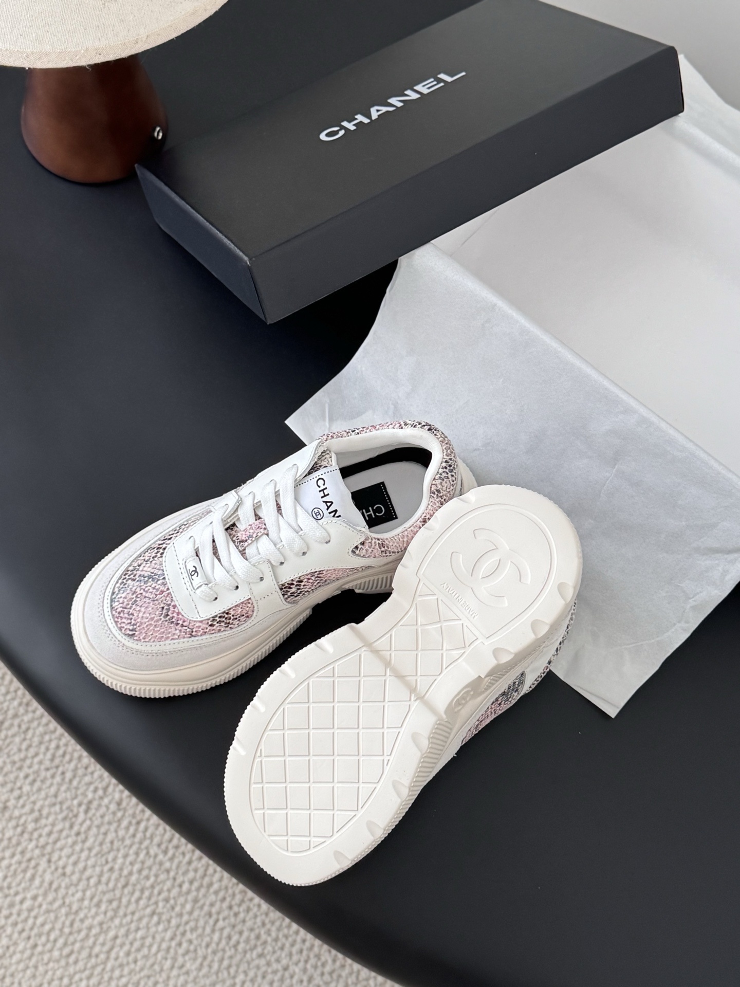 Chanel white leather sneakers with pink python print and chunky soles next to a black Chanel shoe box. - Hình 5