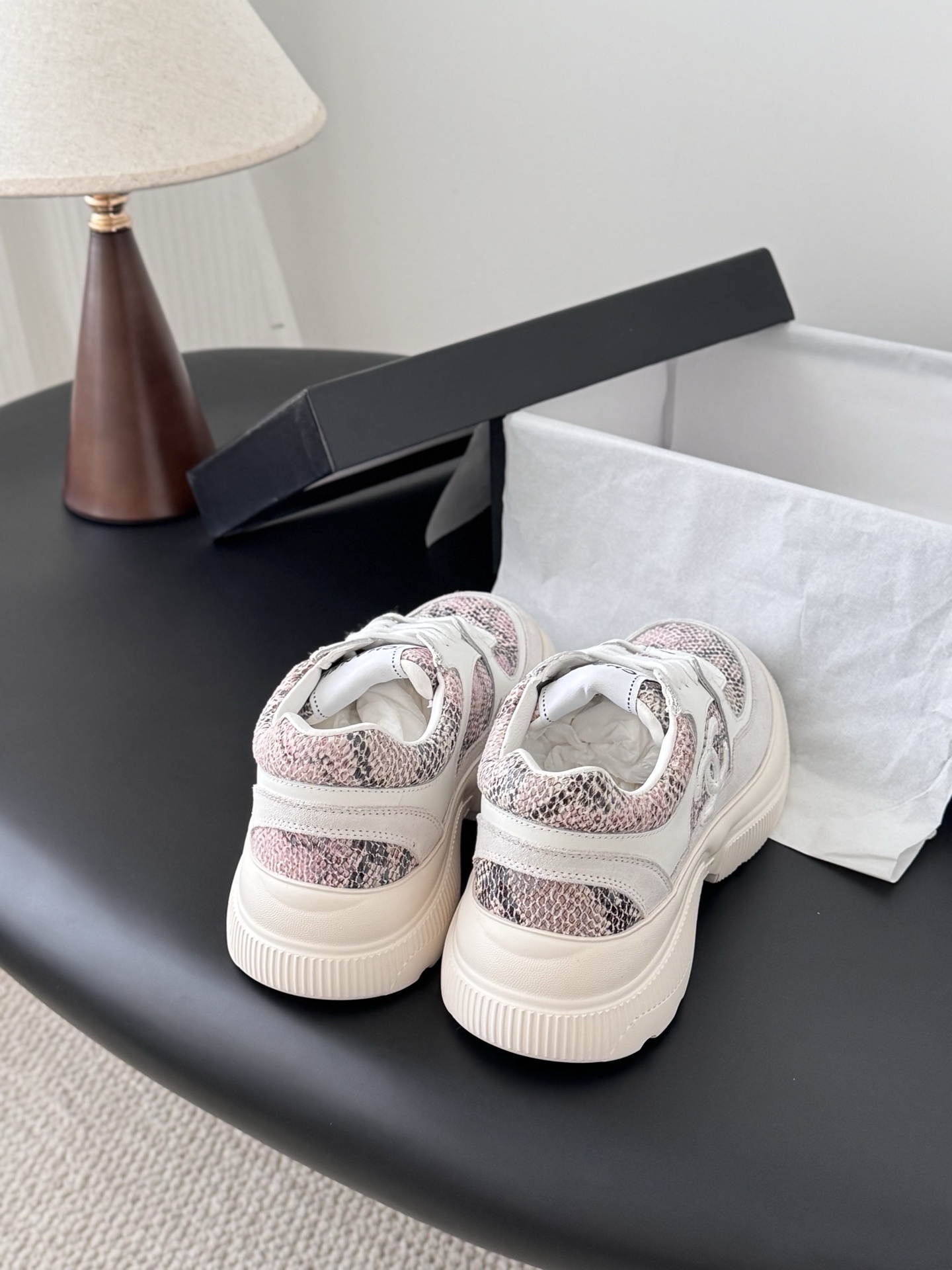 Chanel white leather sneakers with pink python print and chunky soles next to a black Chanel shoe box. - Hình 3