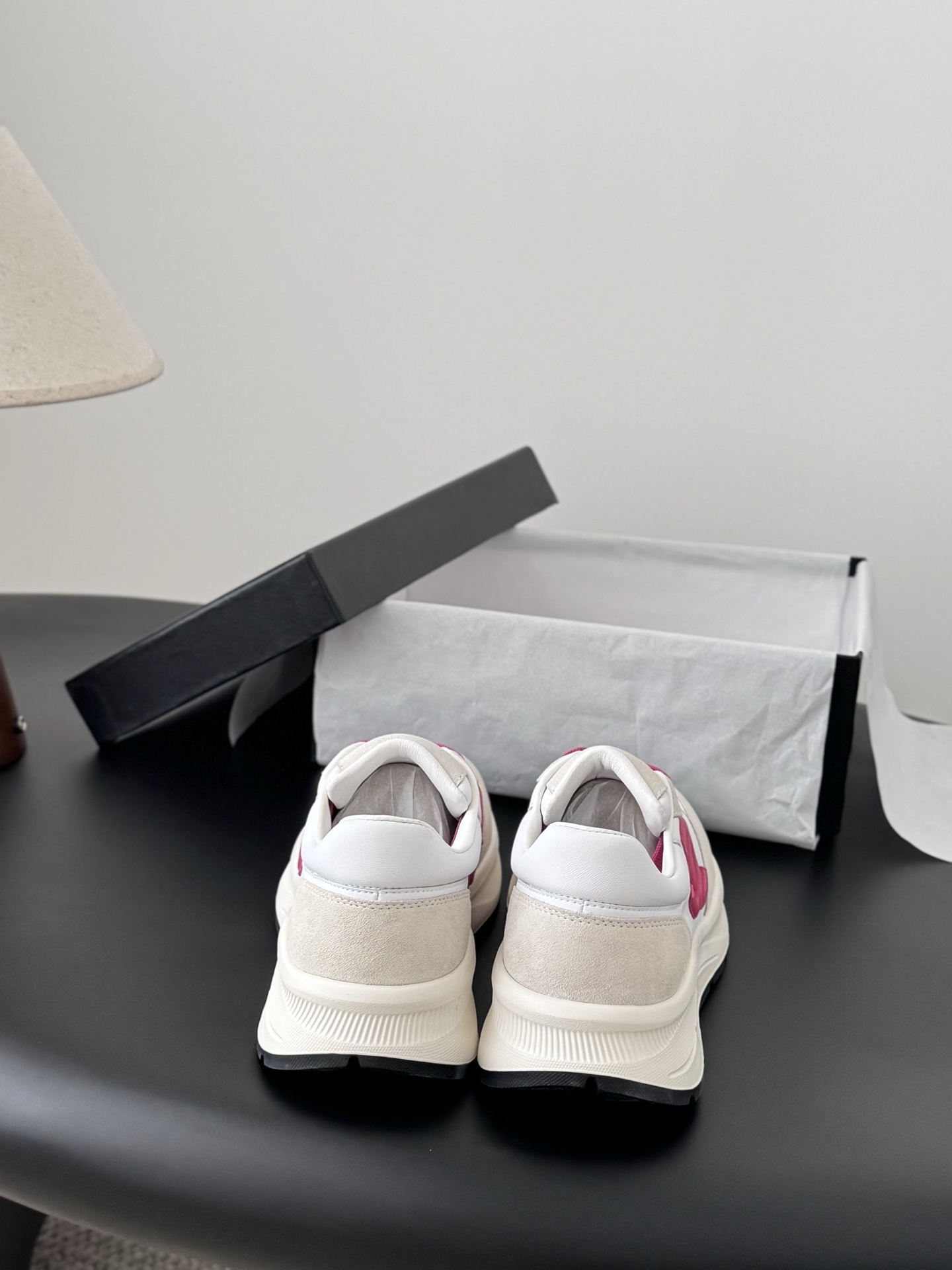 Pair of Chanel white and cream suede sneakers with hot pink laces and logo next to a black Chanel box - Hình 7