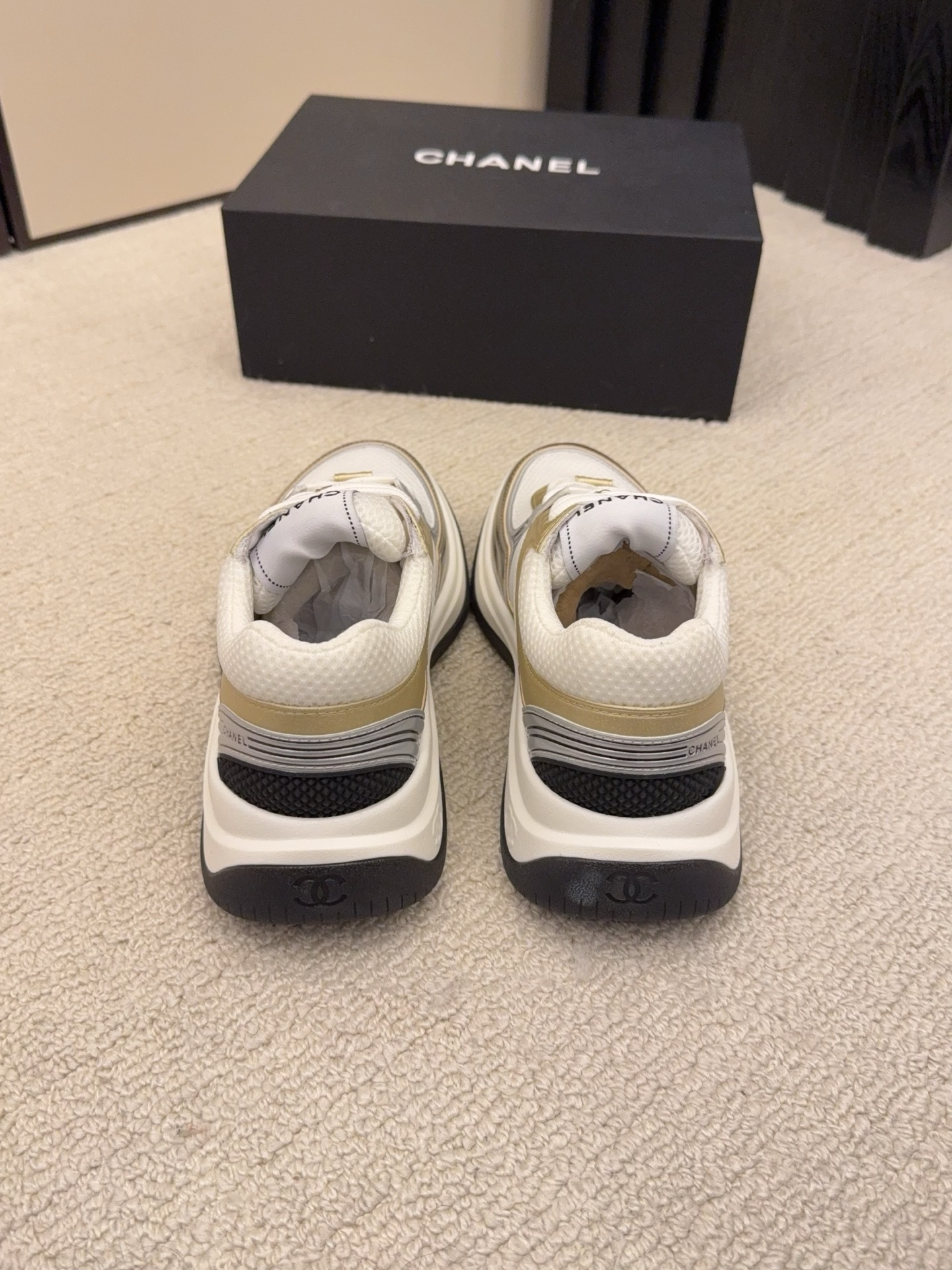 Two pairs of Chanel metallic mesh sneakers in silver and gold colorways displayed on a black Chanel box. - Hình 7