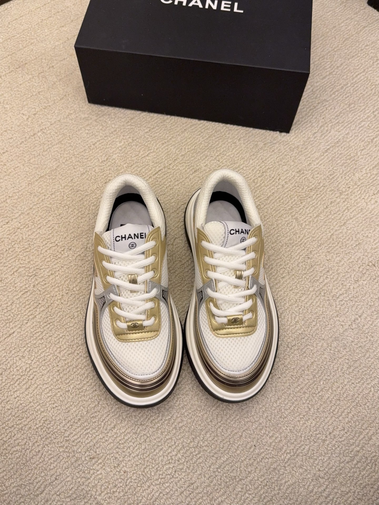 Two pairs of Chanel metallic mesh sneakers in silver and gold colorways displayed on a black Chanel box. - Hình 6