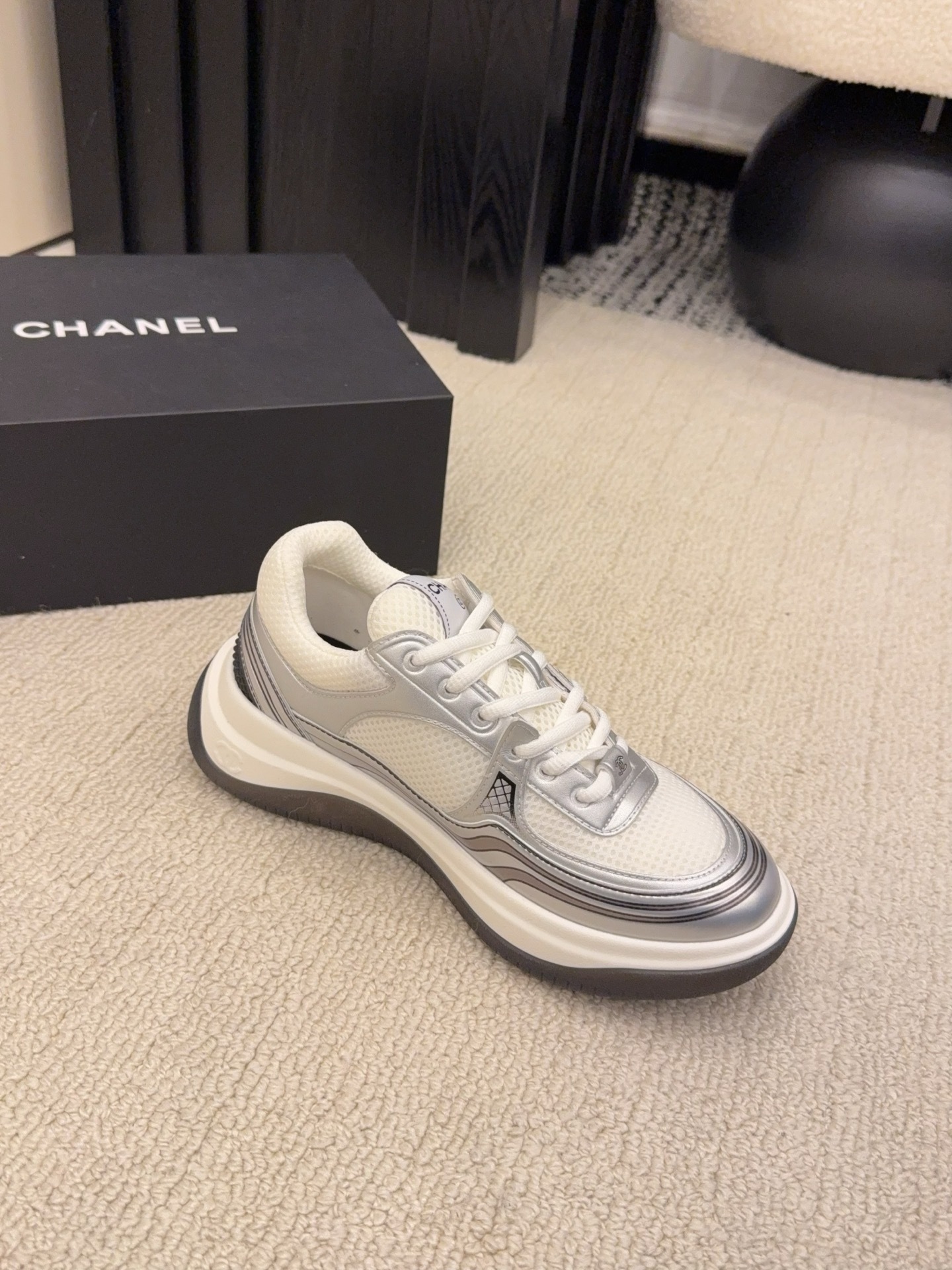 Two pairs of Chanel metallic mesh sneakers in silver and gold colorways displayed on a black Chanel box. - Hình 4