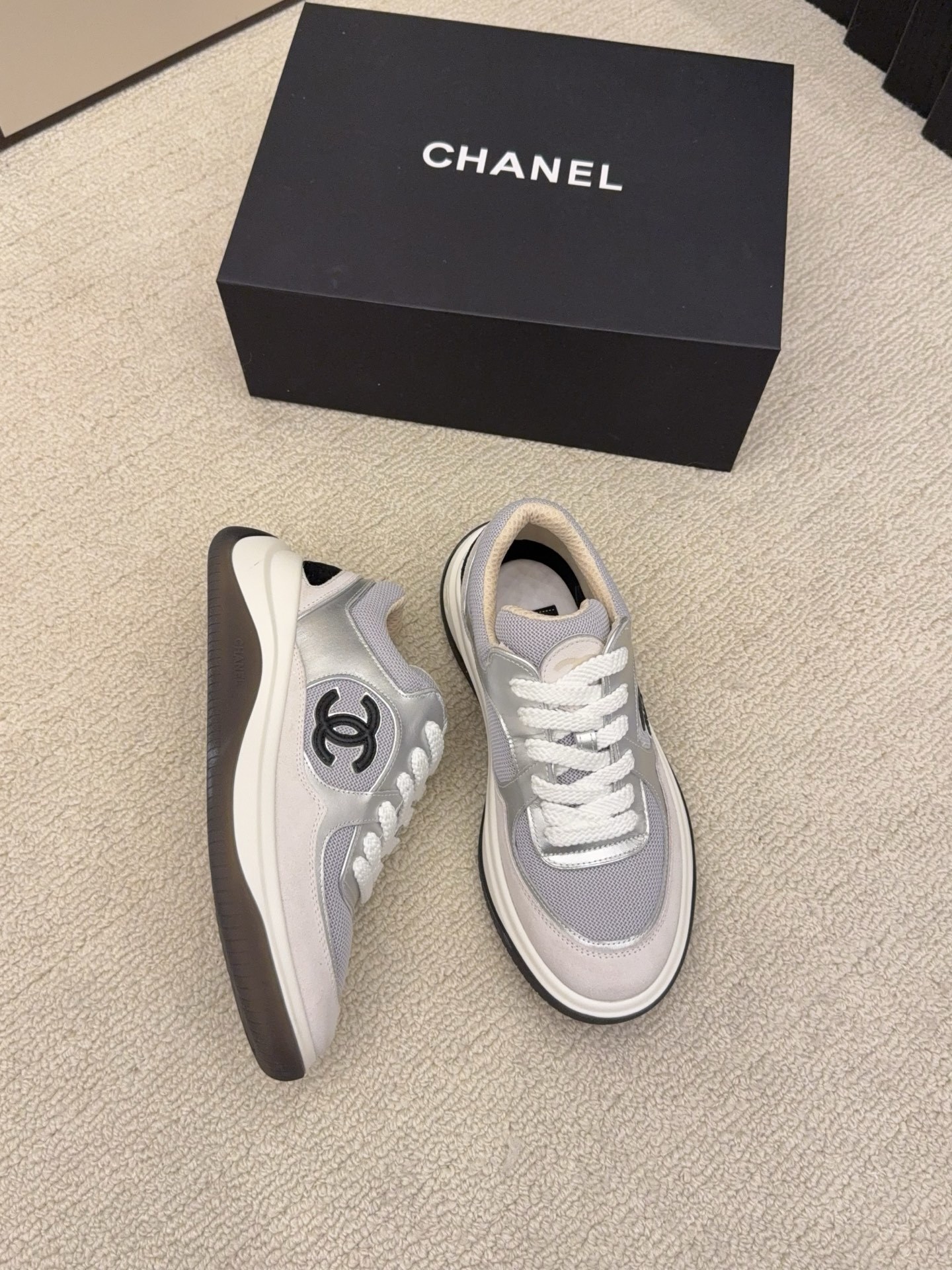 Premium Chanel sneakers in grey and silver mesh with the signature black CC logo on the side, shown with original box. - Hình 3
