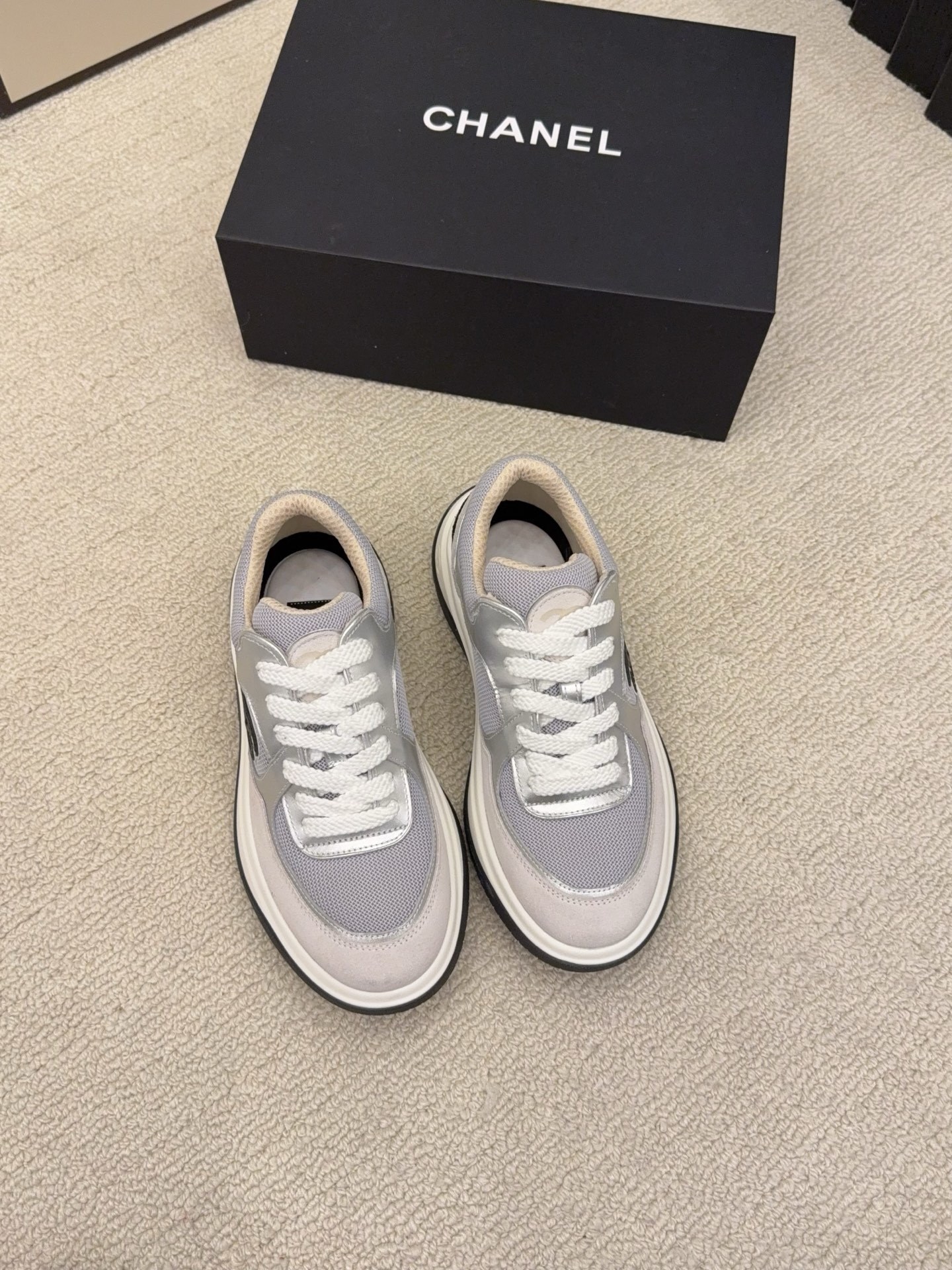 Premium Chanel sneakers in grey and silver mesh with the signature black CC logo on the side, shown with original box. - Hình 2