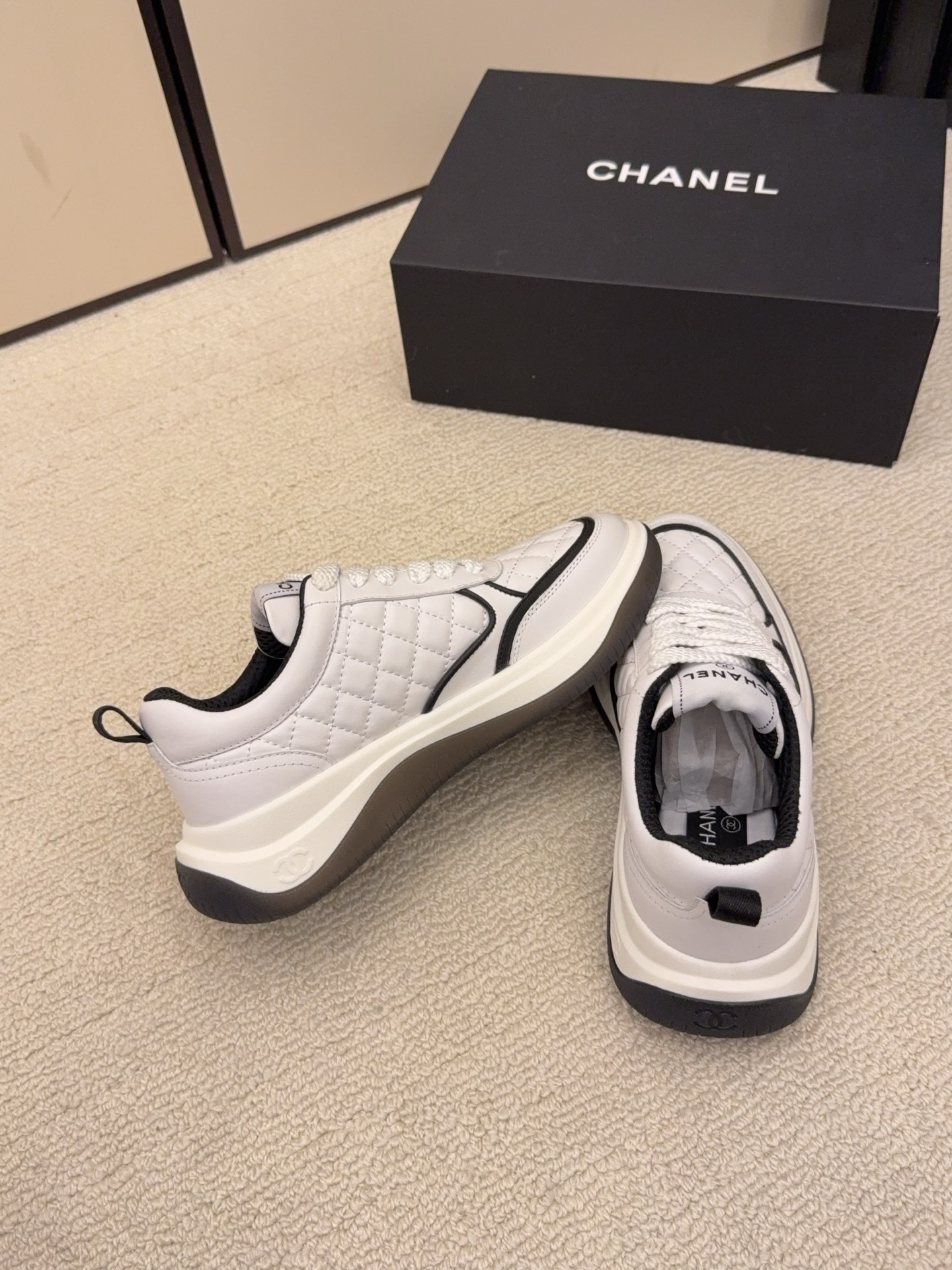 Chanel luxury quilted leather sneakers in black and white featuring the interlocking CC logo on the side. - Hình 9