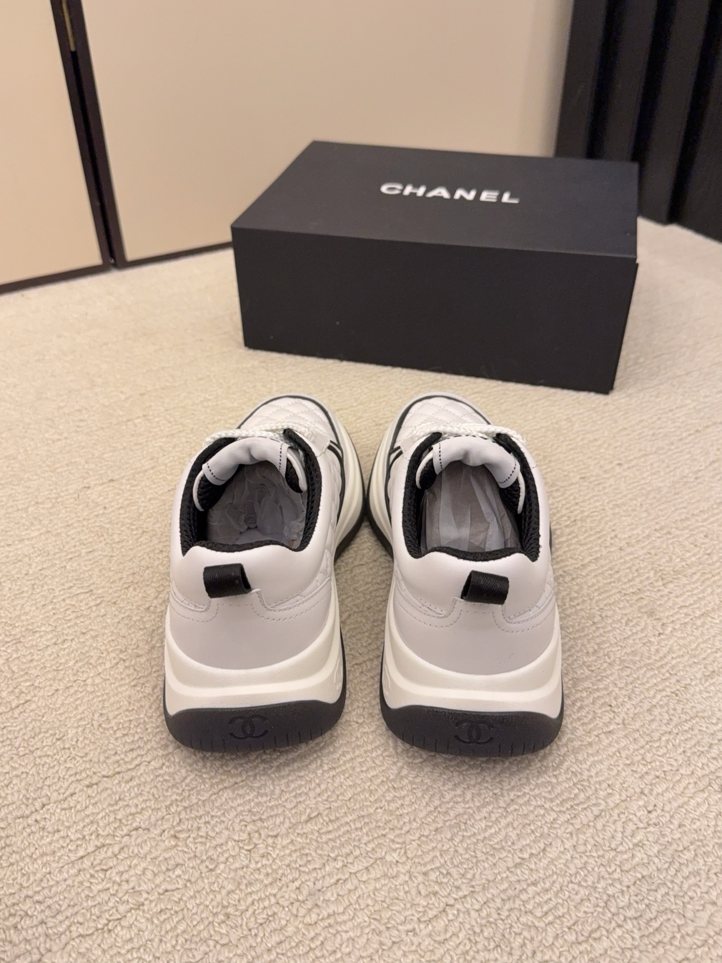 Chanel luxury quilted leather sneakers in black and white featuring the interlocking CC logo on the side. - Hình 8