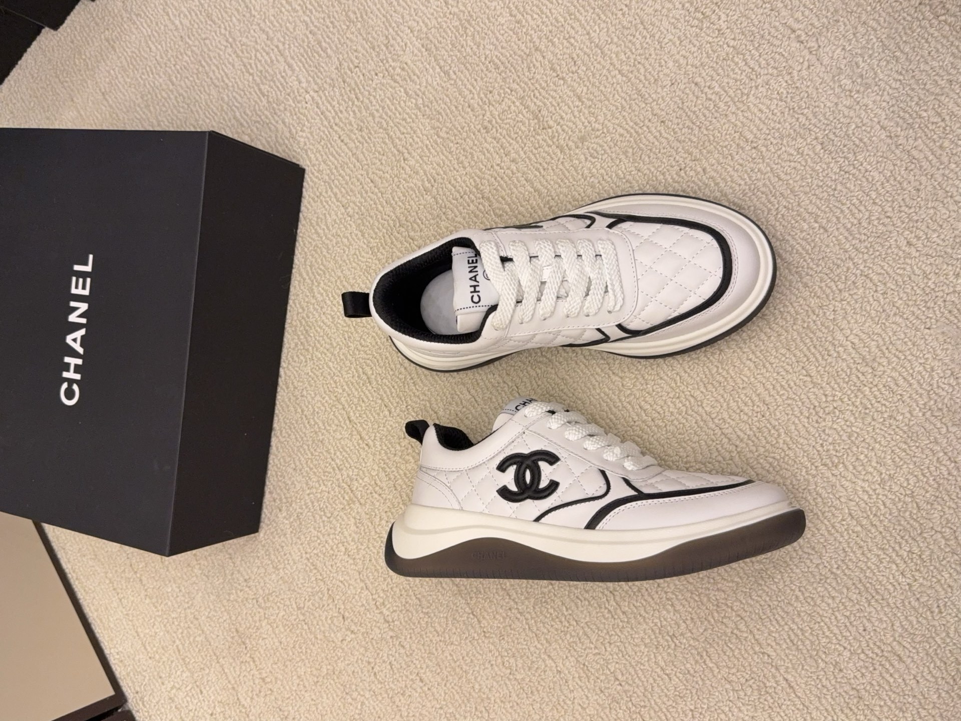 Chanel luxury quilted leather sneakers in black and white featuring the interlocking CC logo on the side. - Hình 7