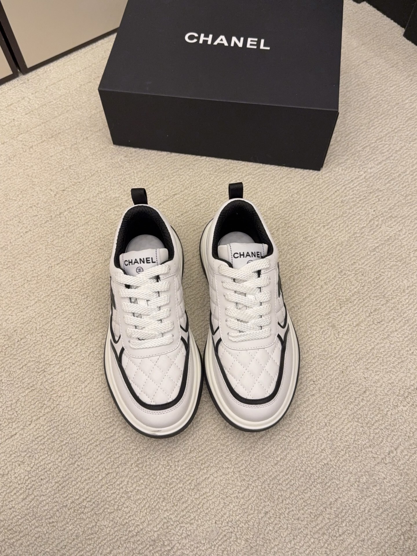Chanel luxury quilted leather sneakers in black and white featuring the interlocking CC logo on the side. - Hình 6