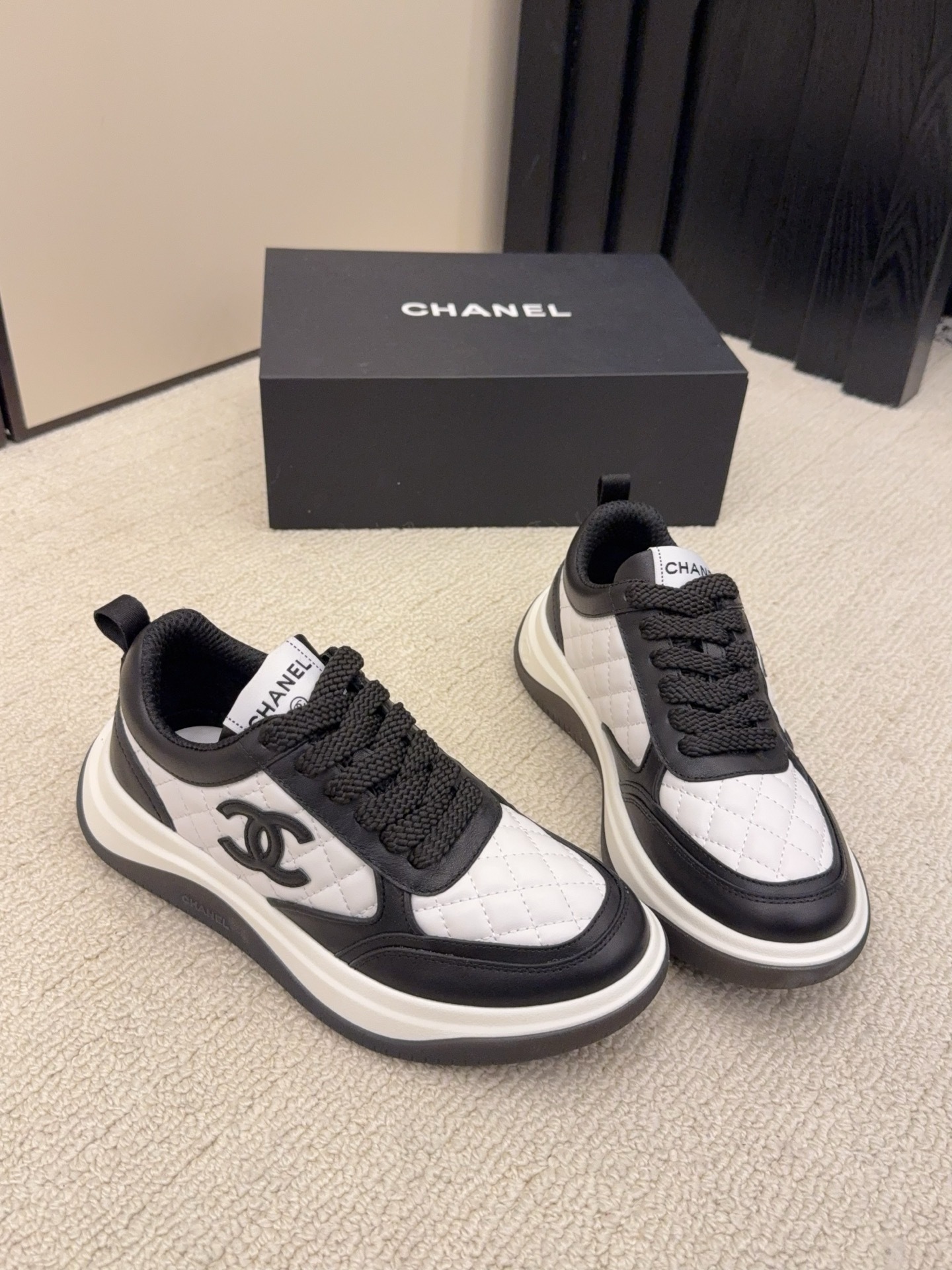 Chanel luxury quilted leather sneakers in black and white featuring the interlocking CC logo on the side. - Hình 4