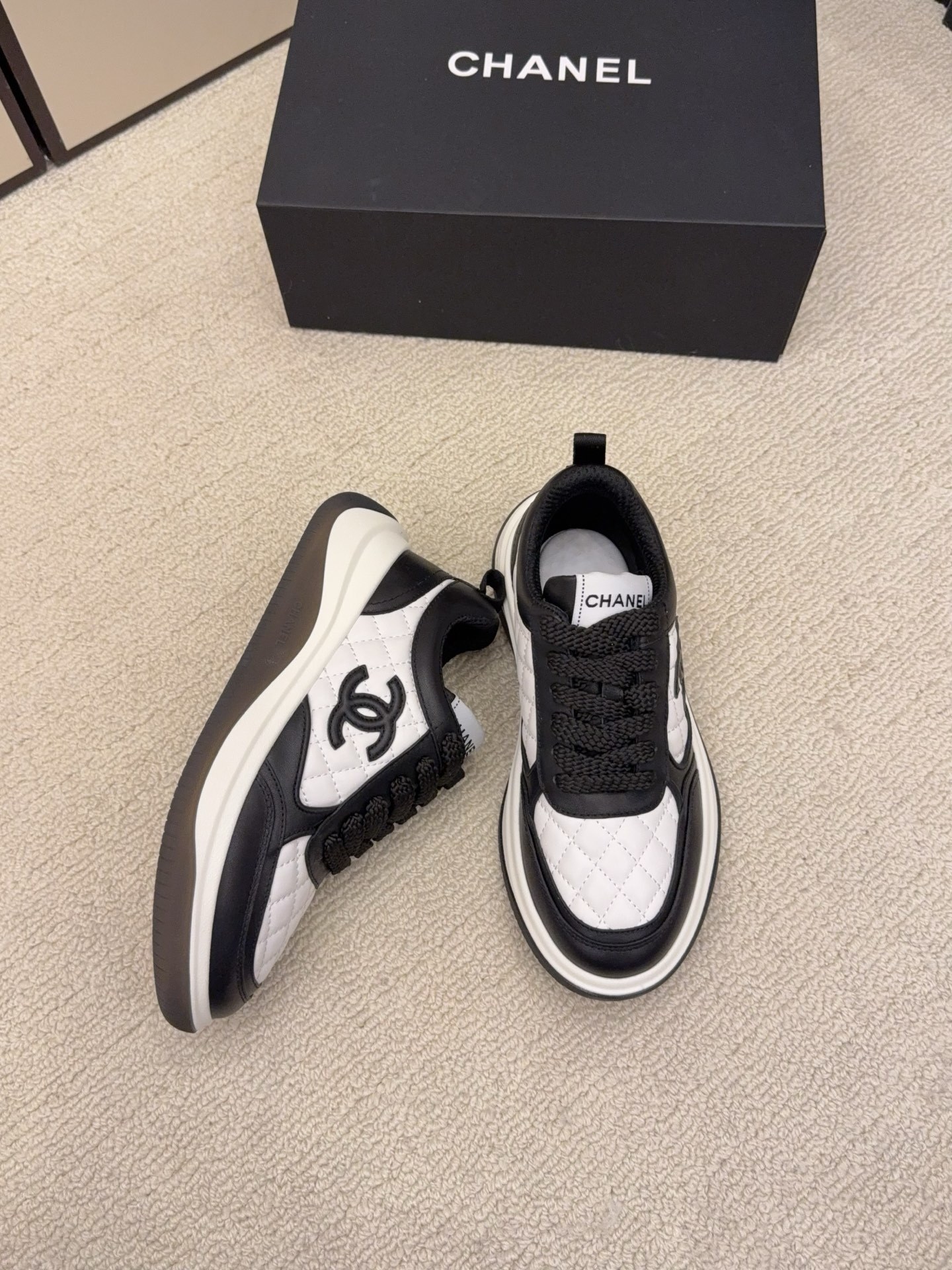 Chanel luxury quilted leather sneakers in black and white featuring the interlocking CC logo on the side. - Hình 3