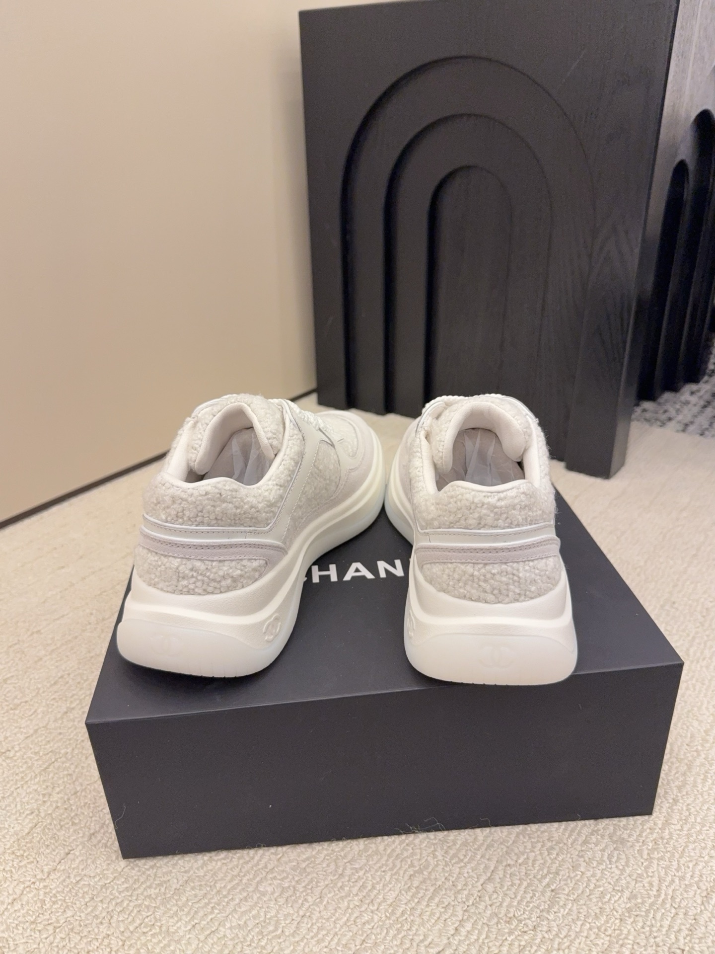 Luxury Chanel white sneakers with shearling texture and leather panels featuring the CC logo on a black box - Hình 8