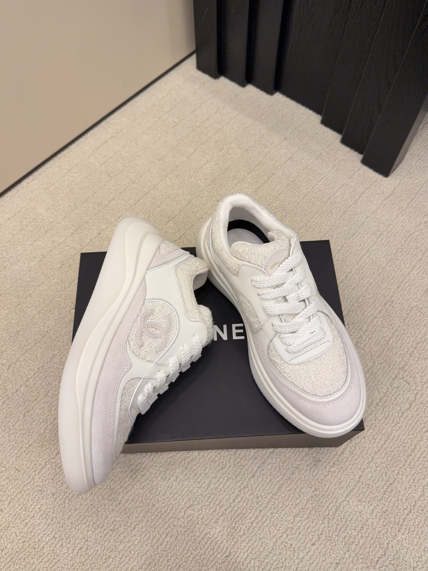Luxury Chanel white sneakers with shearling texture and leather panels featuring the CC logo on a black box - Hình 2