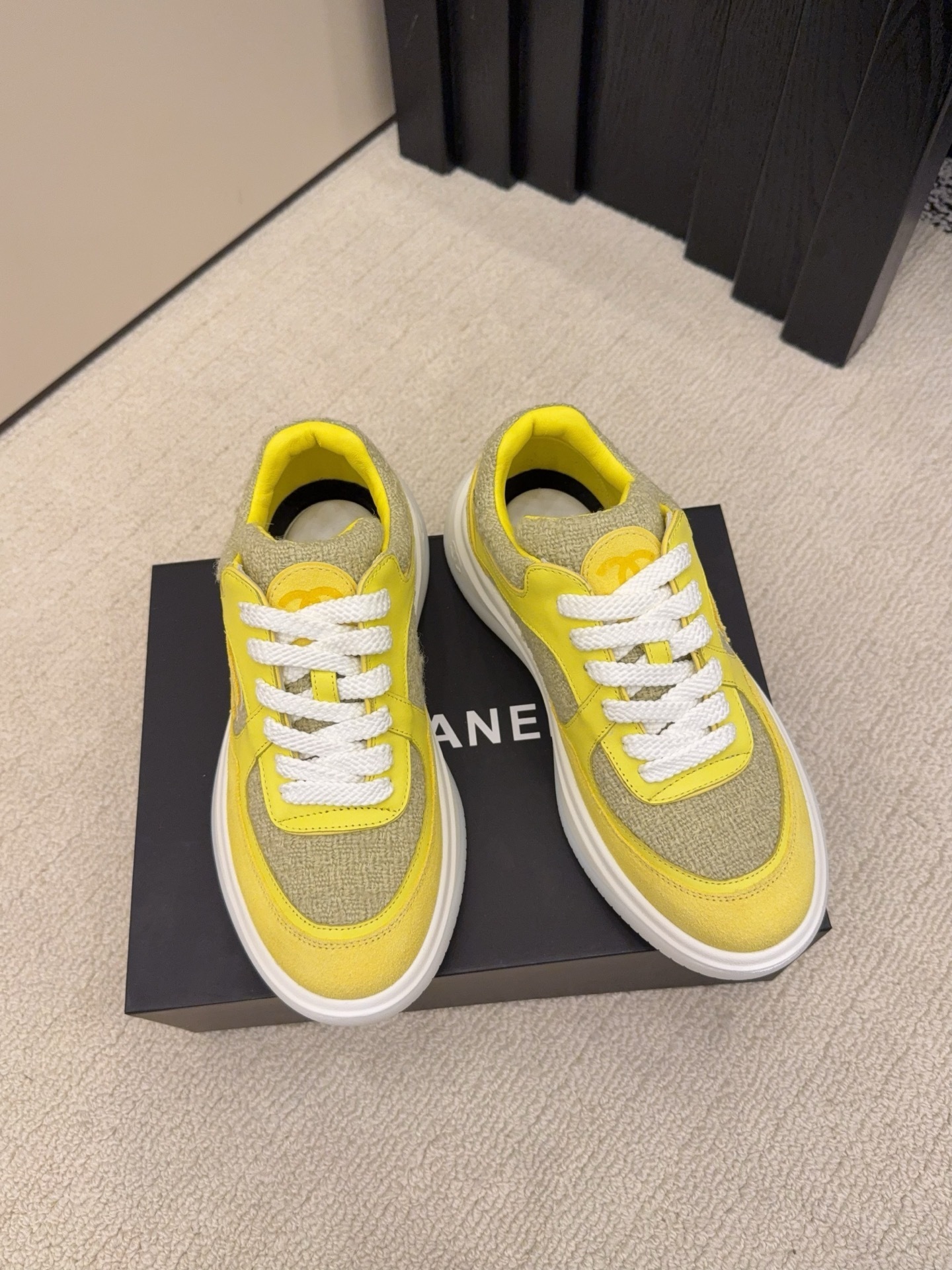 Pair of luxury yellow tweed and suede sneakers with white chunky soles and CC logo on a black box - Hình 2