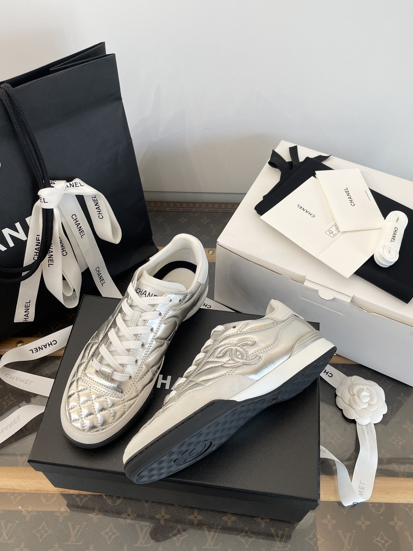 A pair of Chanel metallic silver quilted leather sneakers with CC logo, presented with original black shopping bag and white box. - Hình 9
