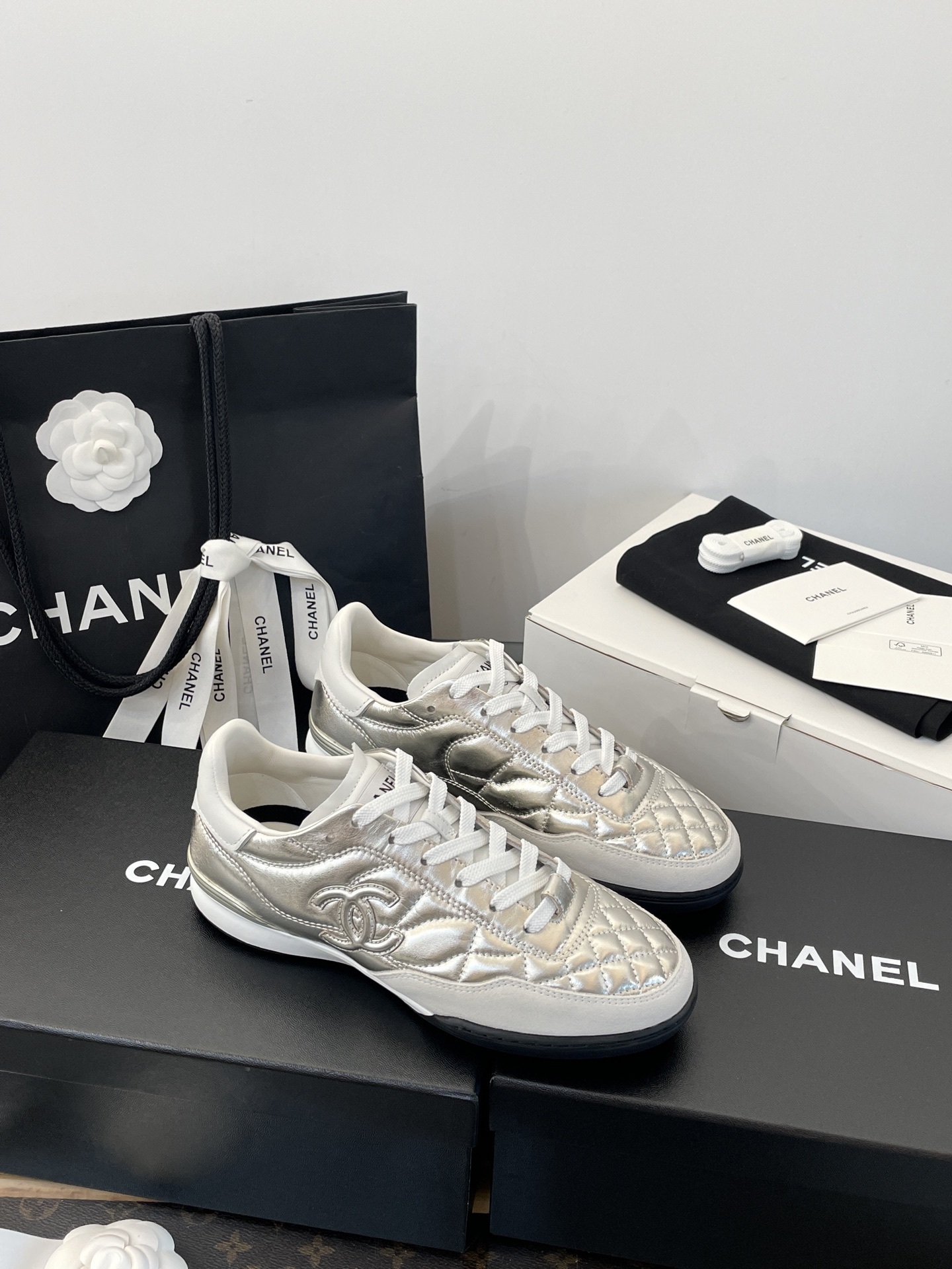 A pair of Chanel metallic silver quilted leather sneakers with CC logo, presented with original black shopping bag and white box. - Hình 5