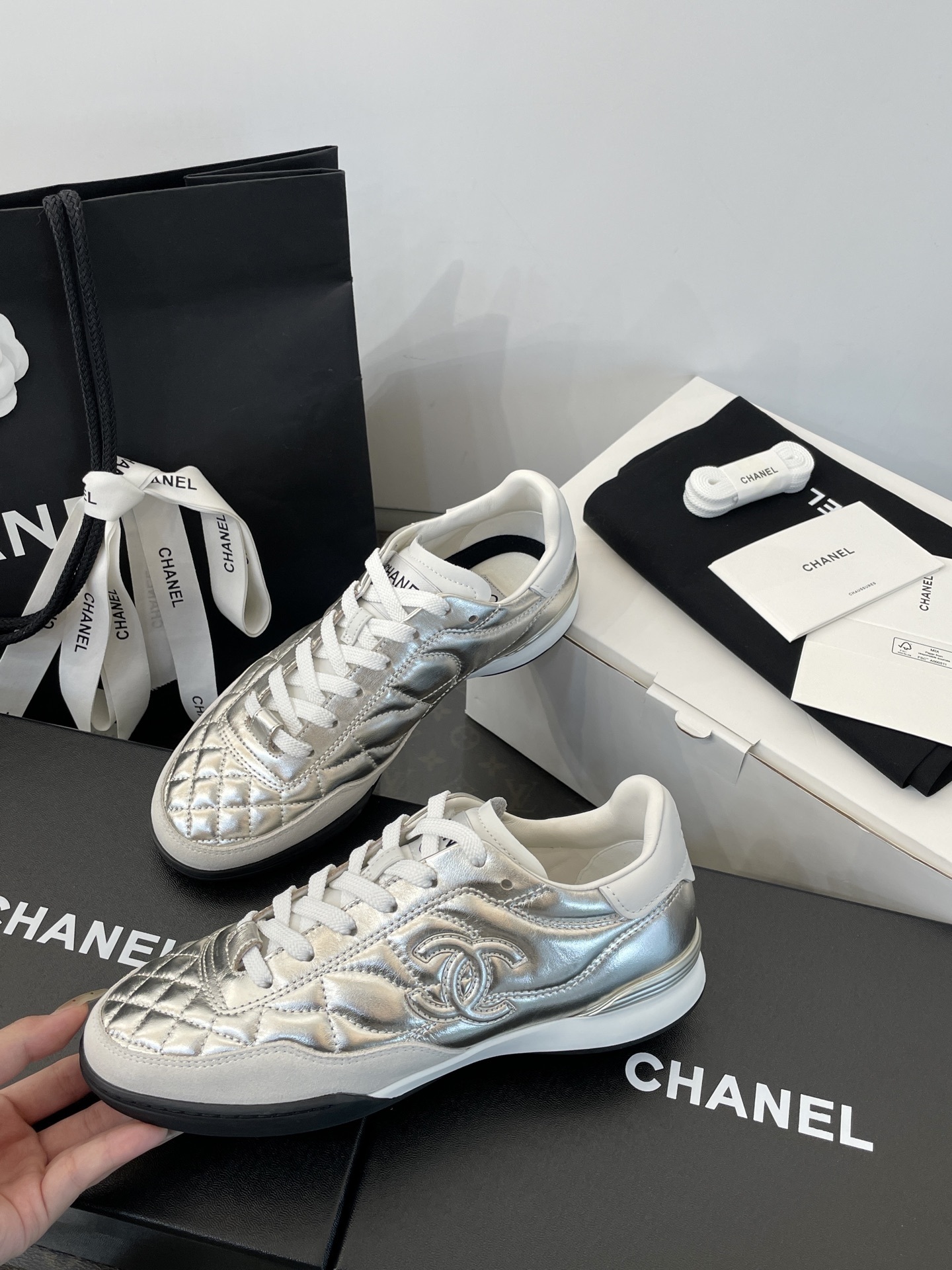 A pair of Chanel metallic silver quilted leather sneakers with CC logo, presented with original black shopping bag and white box. - Hình 4