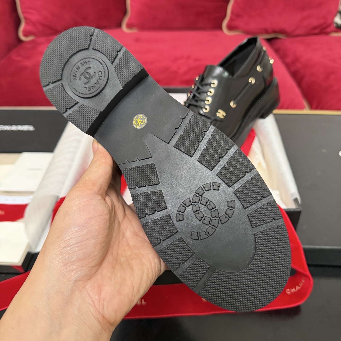 A pair of Chanel black leather lace-up loafers with gold CC logo hardware, displayed in a box with red velvet ribbons. - Hình 9